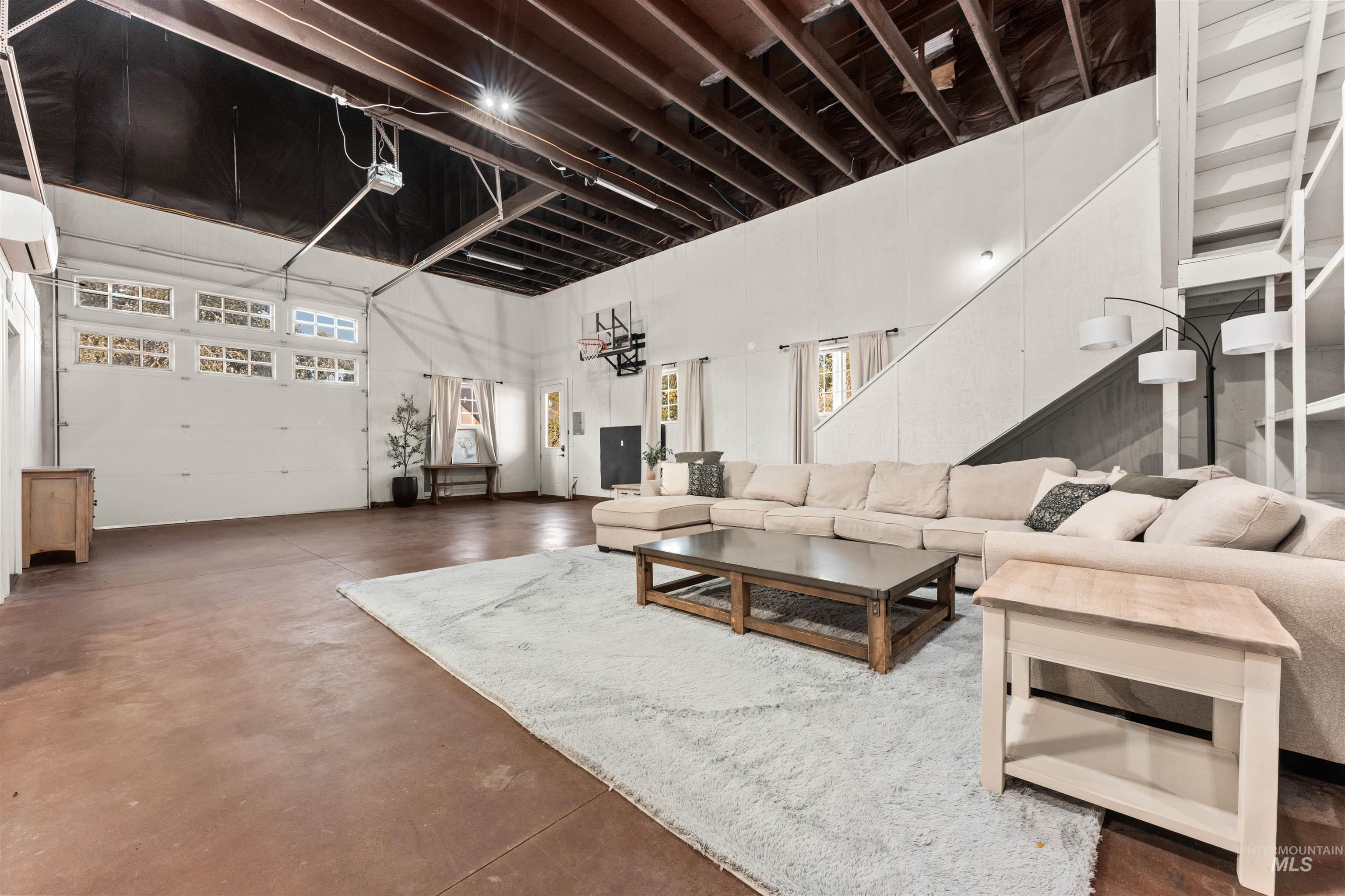 Living room with concrete flooring, healthy amount of natural light, and a high ceiling