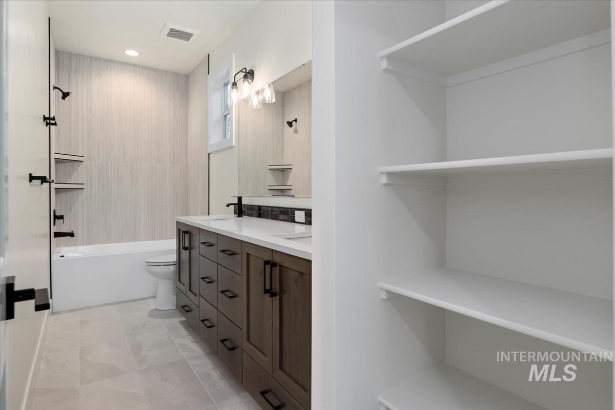 Full bath with double vanity and shower / bath combination