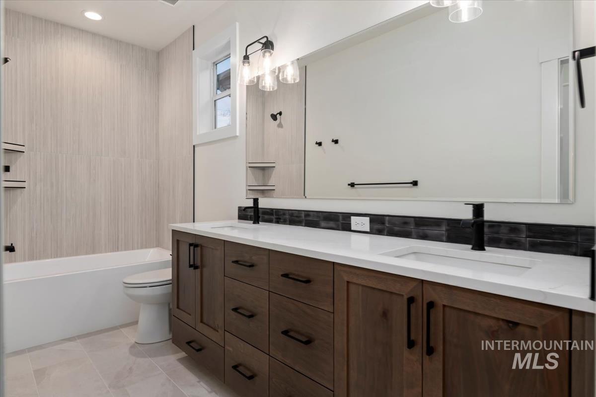 Bathroom with double vanity and washtub / shower combination