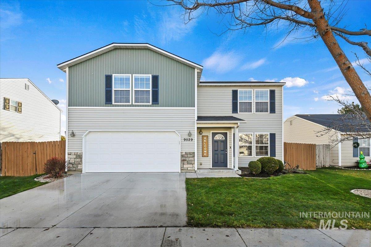 Traditional home with driveway, a garage, and board and batten siding