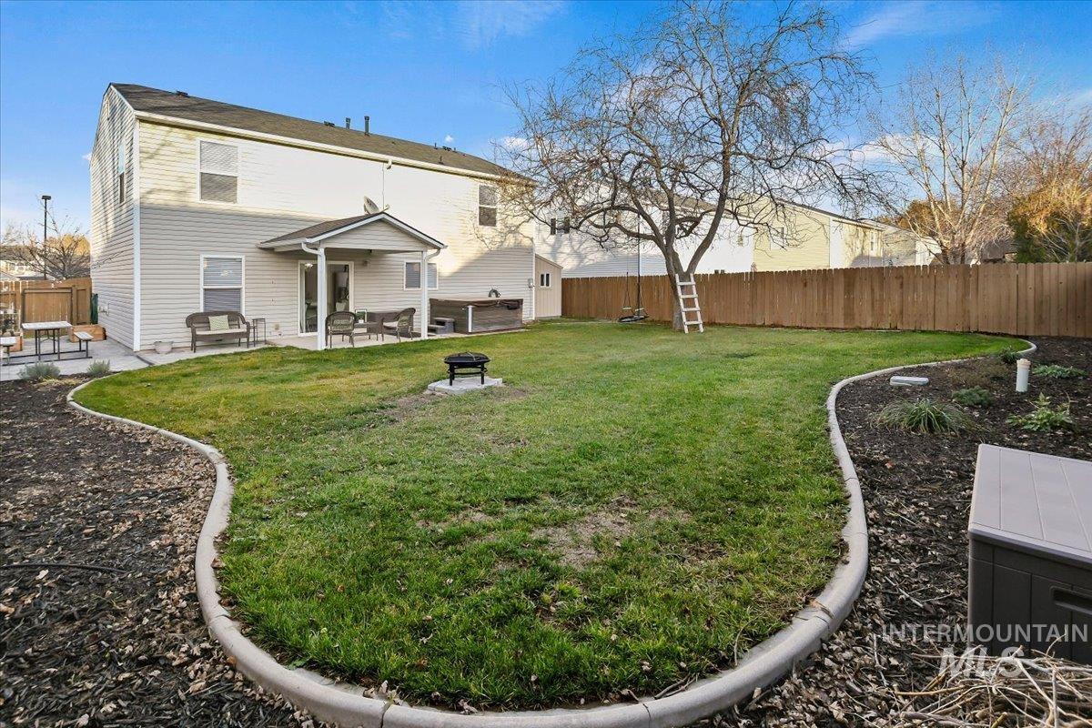 Back of property with a fenced backyard, a patio, and an outdoor fire pit