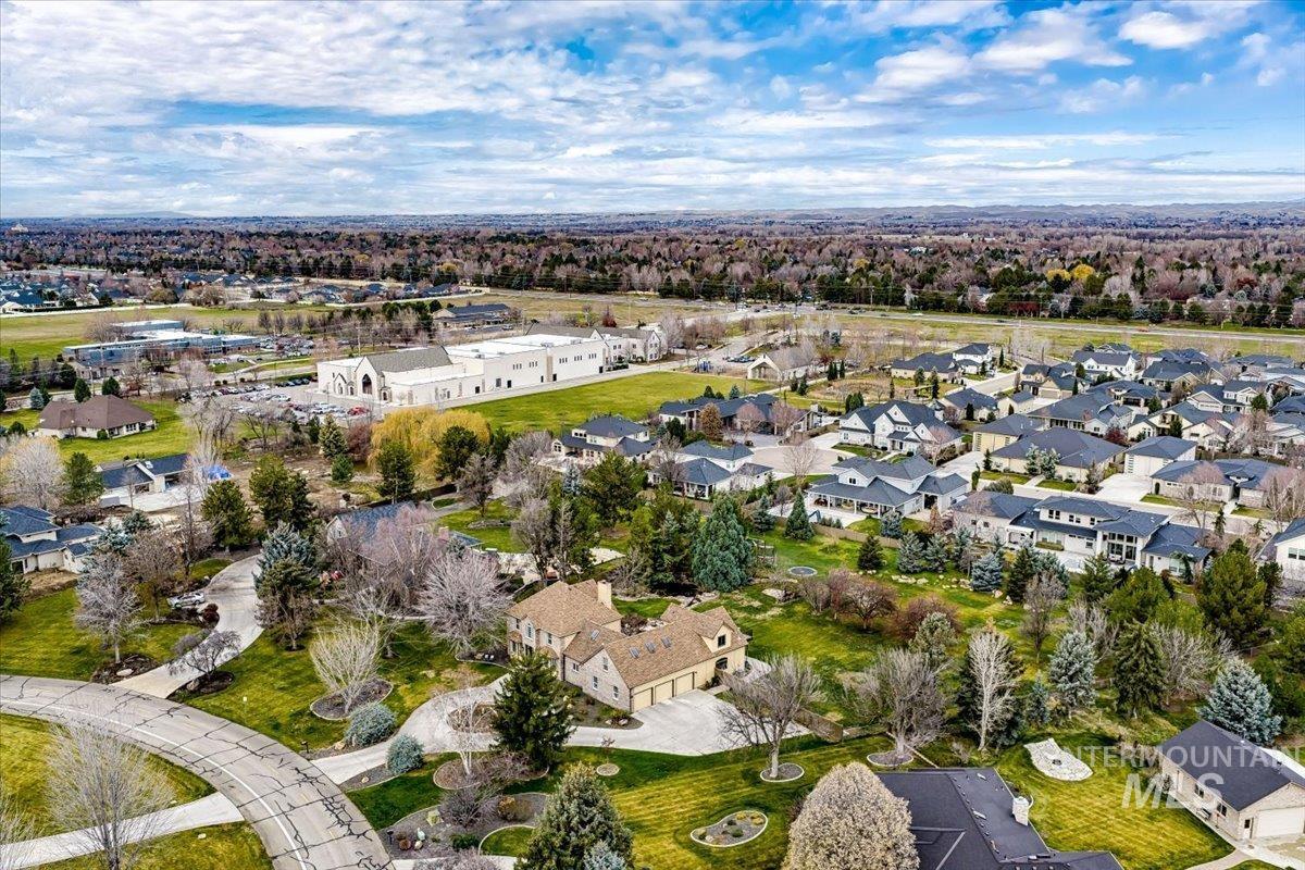 Aerial view of property and surrounding area featuring nearby suburban area