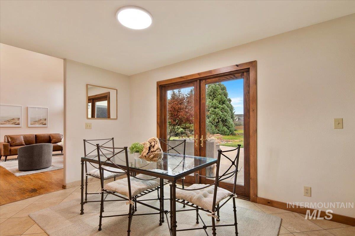 Dining room featuring light tile patterned floors and french doors