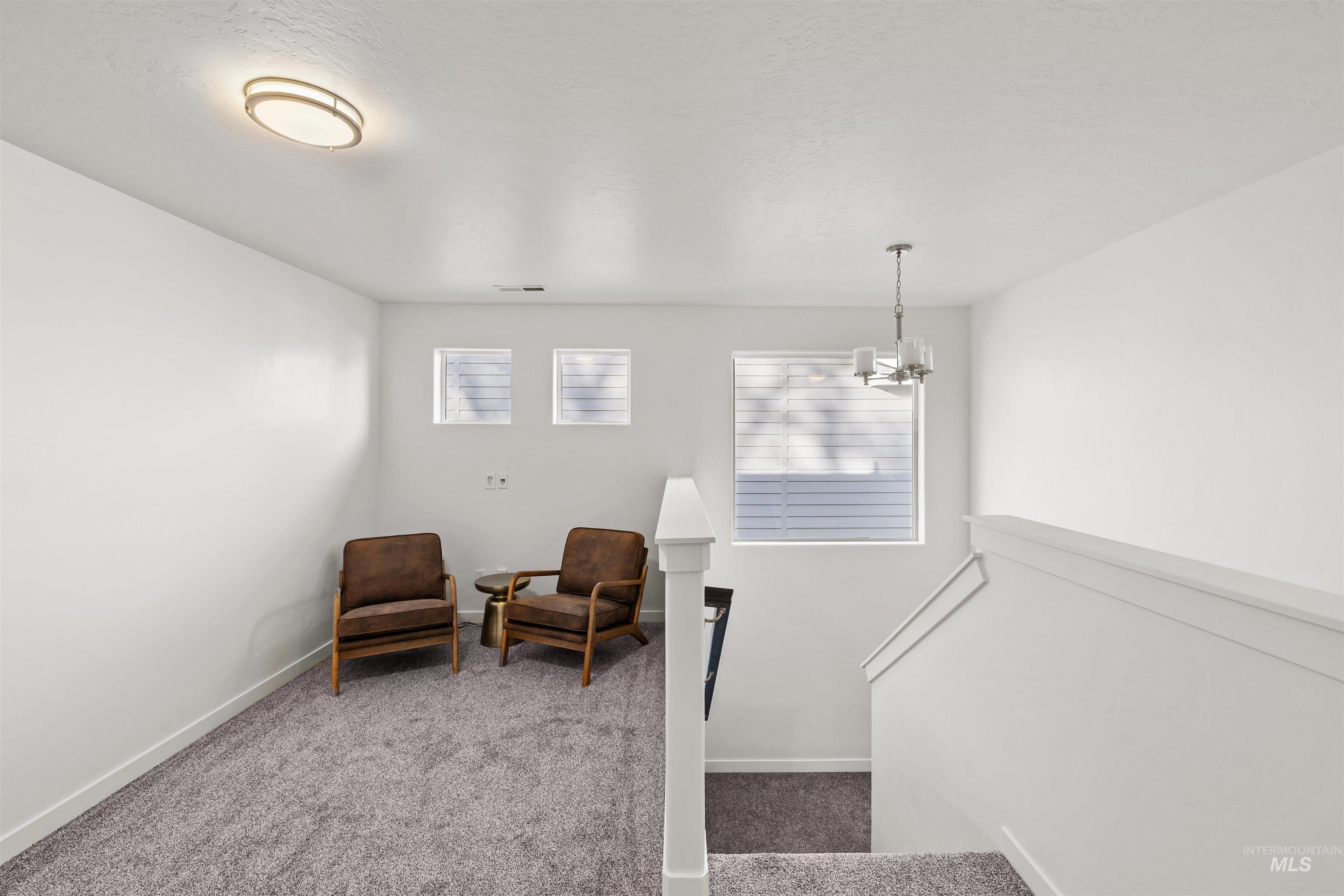 Stairs with carpet floors, a chandelier, and a textured ceiling