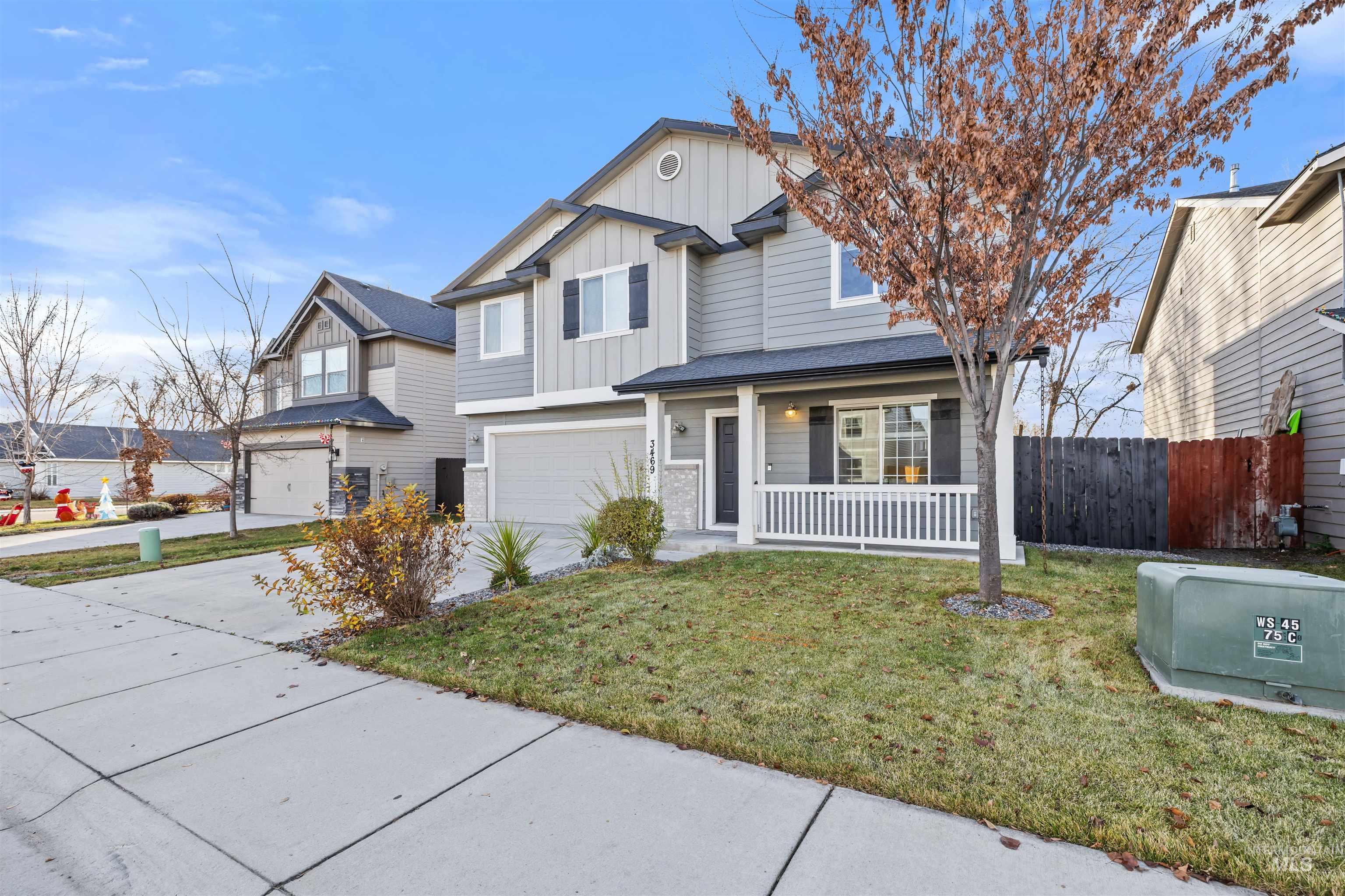 View of front of house featuring board and batten siding, covered porch, concrete driveway, and an attached garage