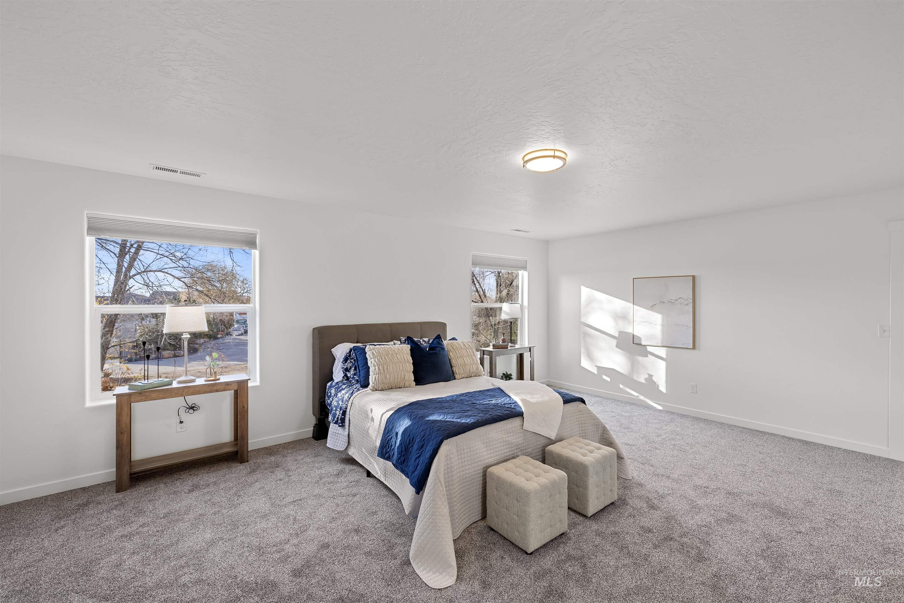 Bedroom with a textured ceiling and carpet floors