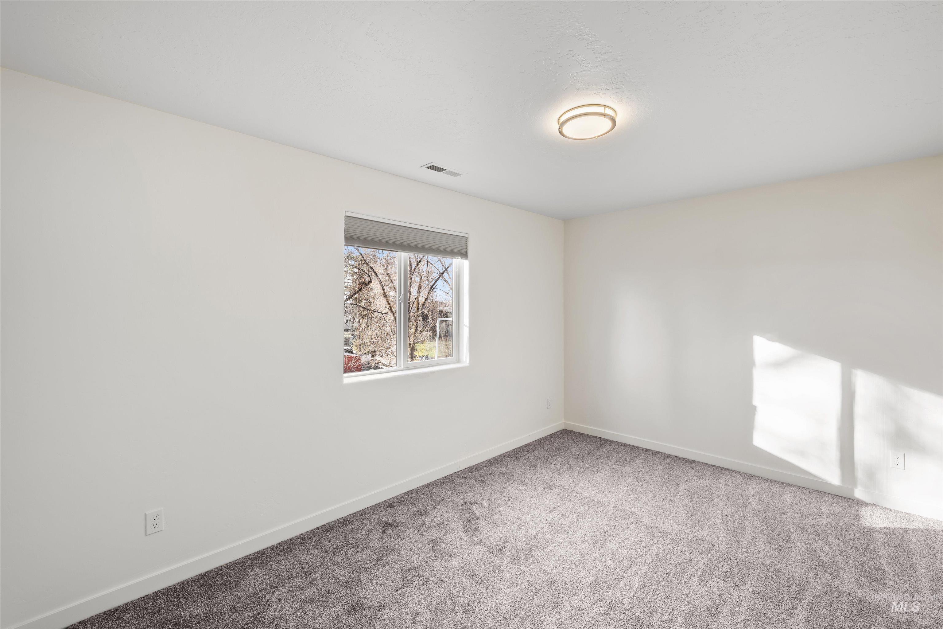 Carpeted empty room featuring baseboards