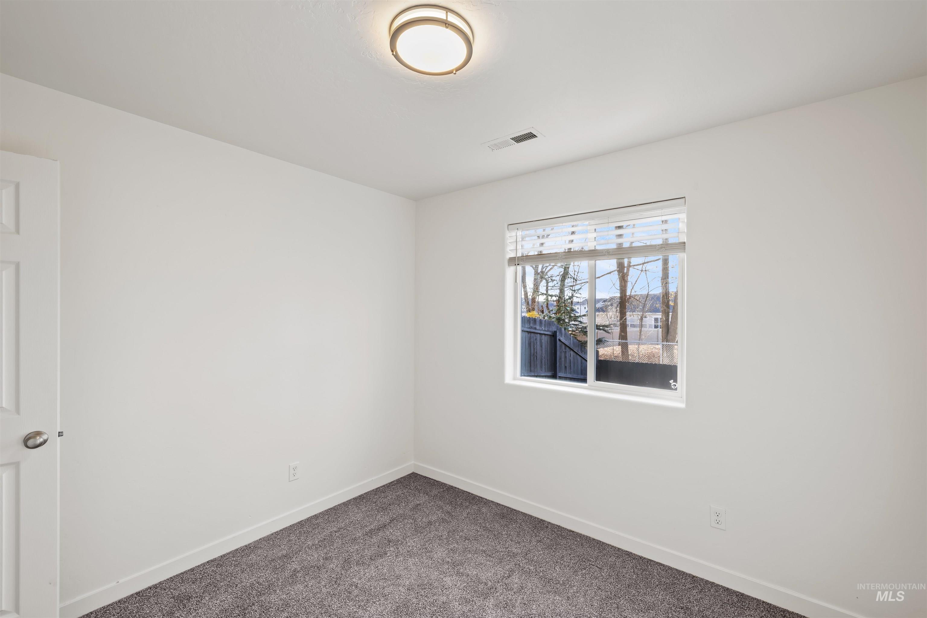 Spare room with baseboards and carpet