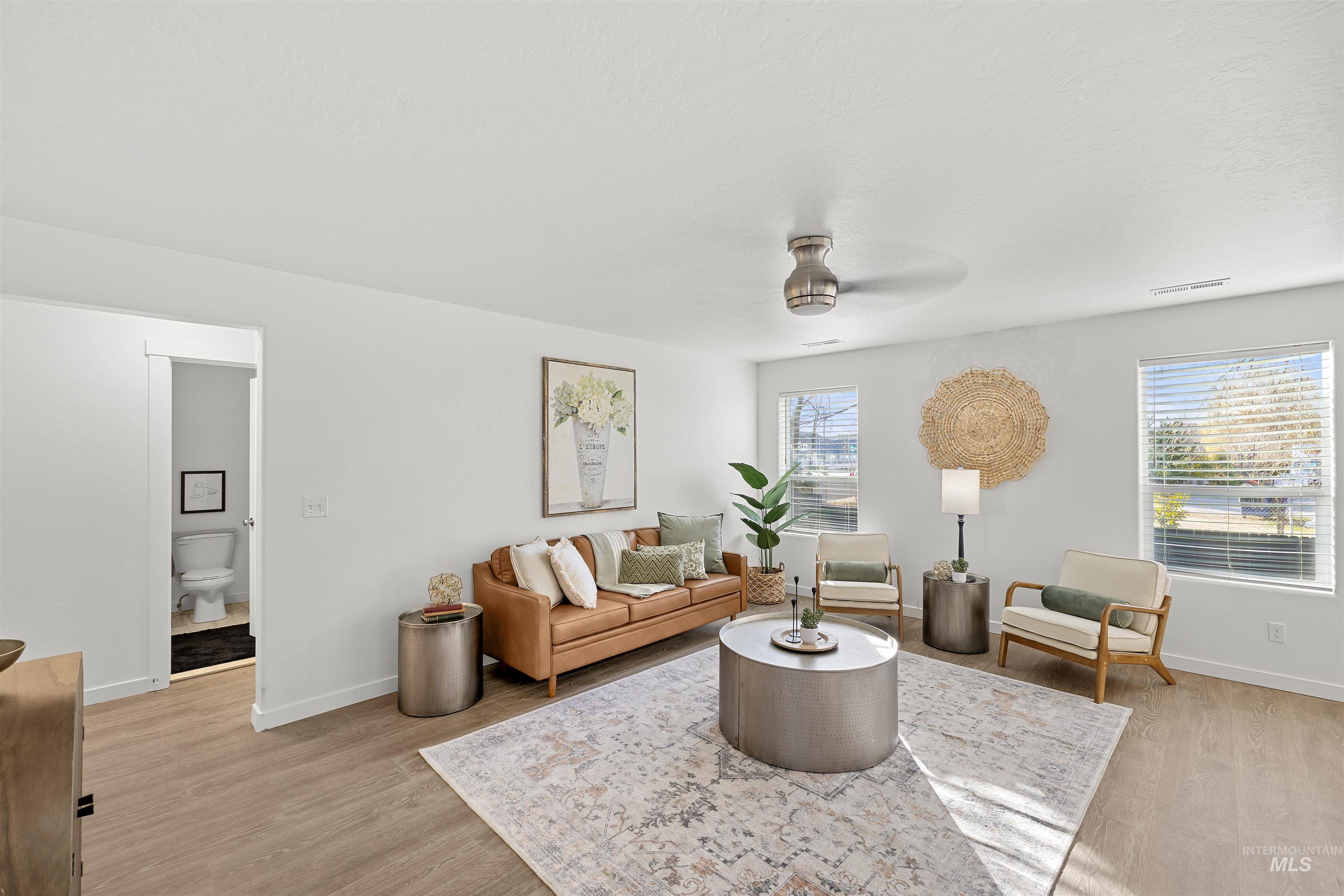 Living room with light wood-style floors and ceiling fan