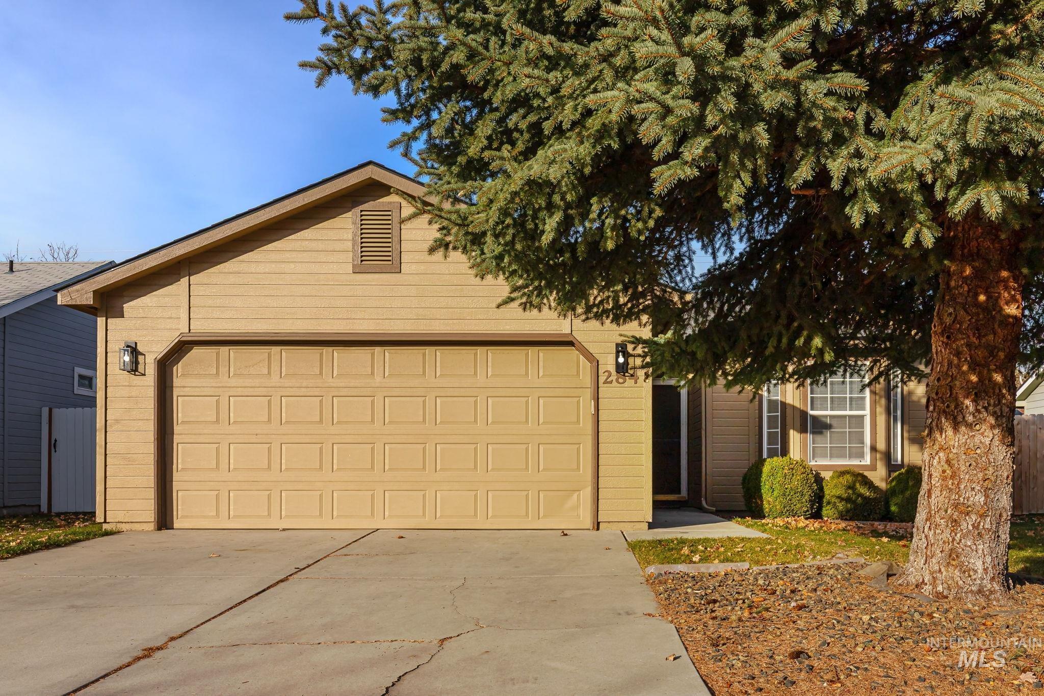 View of front of property featuring concrete driveway and an attached garage