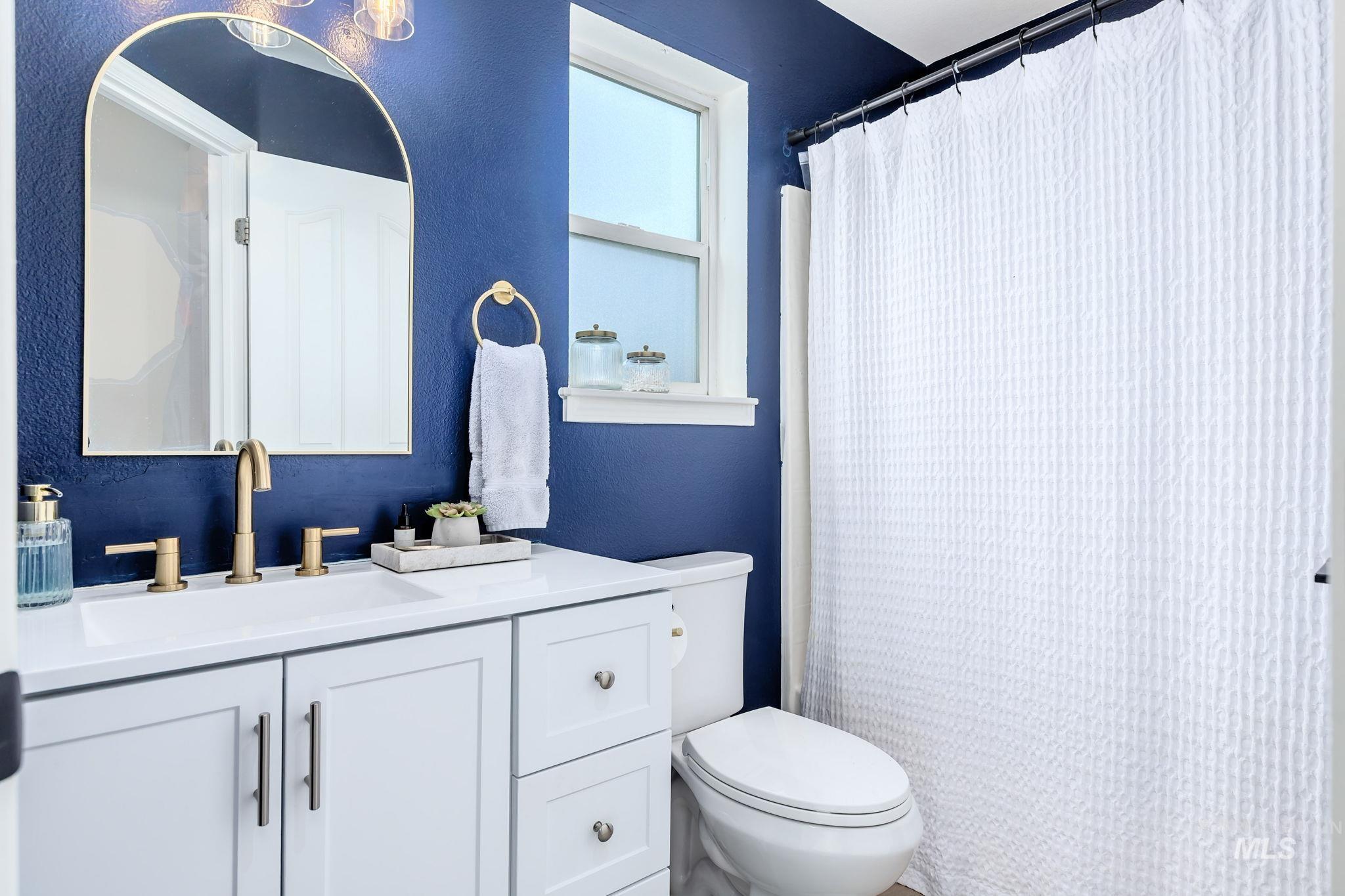 Full bath featuring vanity, a shower with curtain, and a textured wall