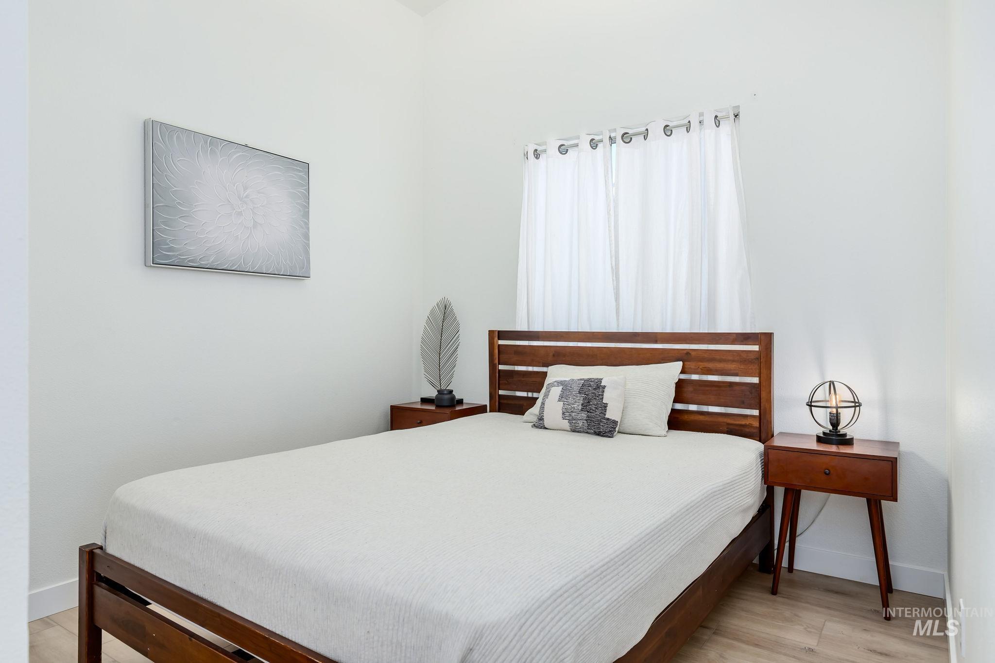 Bedroom with light wood-type flooring and baseboards