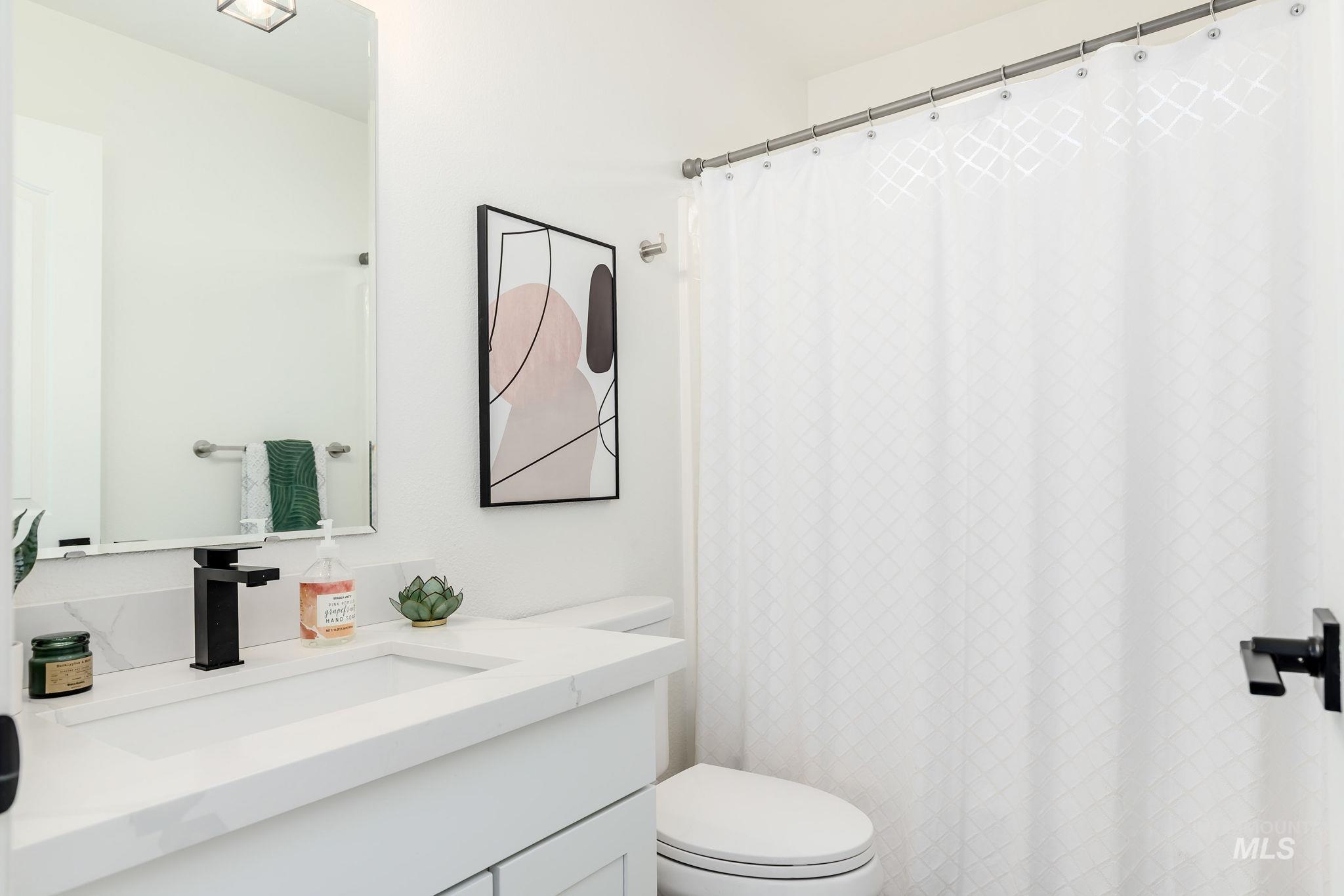 Bathroom with vanity and curtained shower