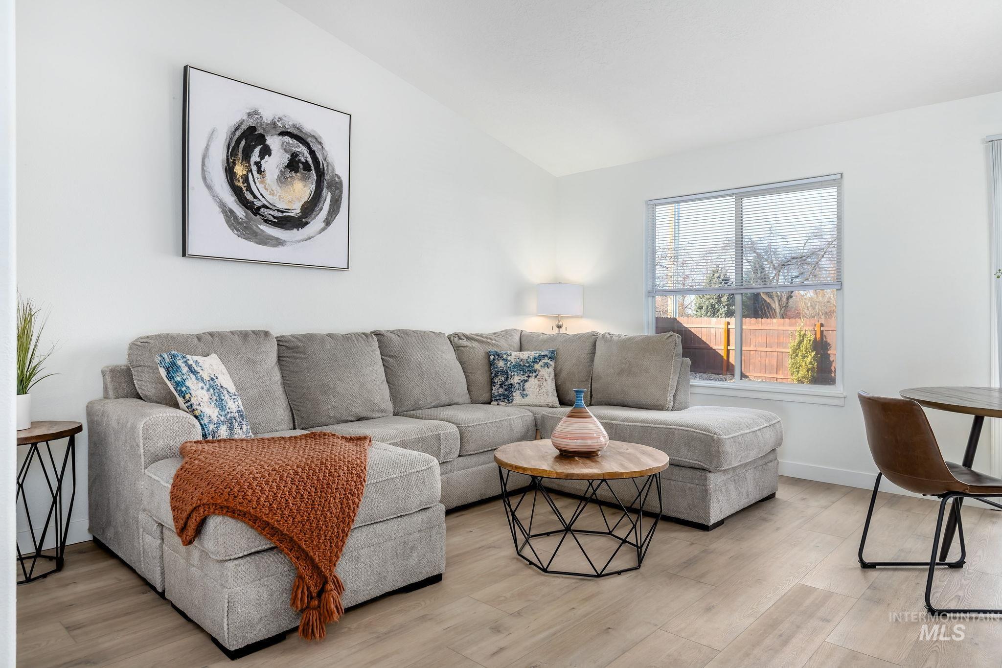 Living room featuring vaulted ceiling and light wood finished floors