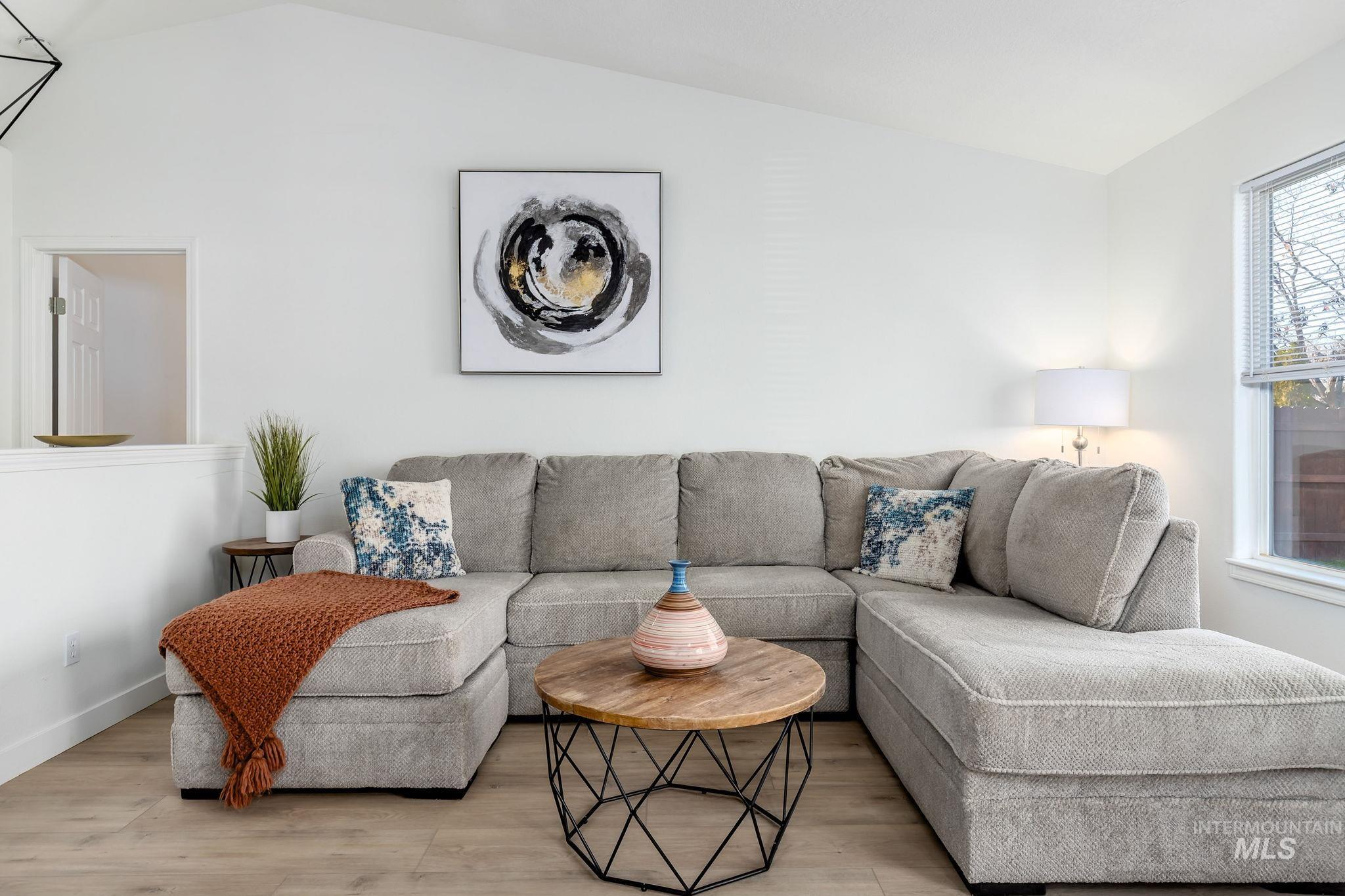 Living area with lofted ceiling and wood finished floors