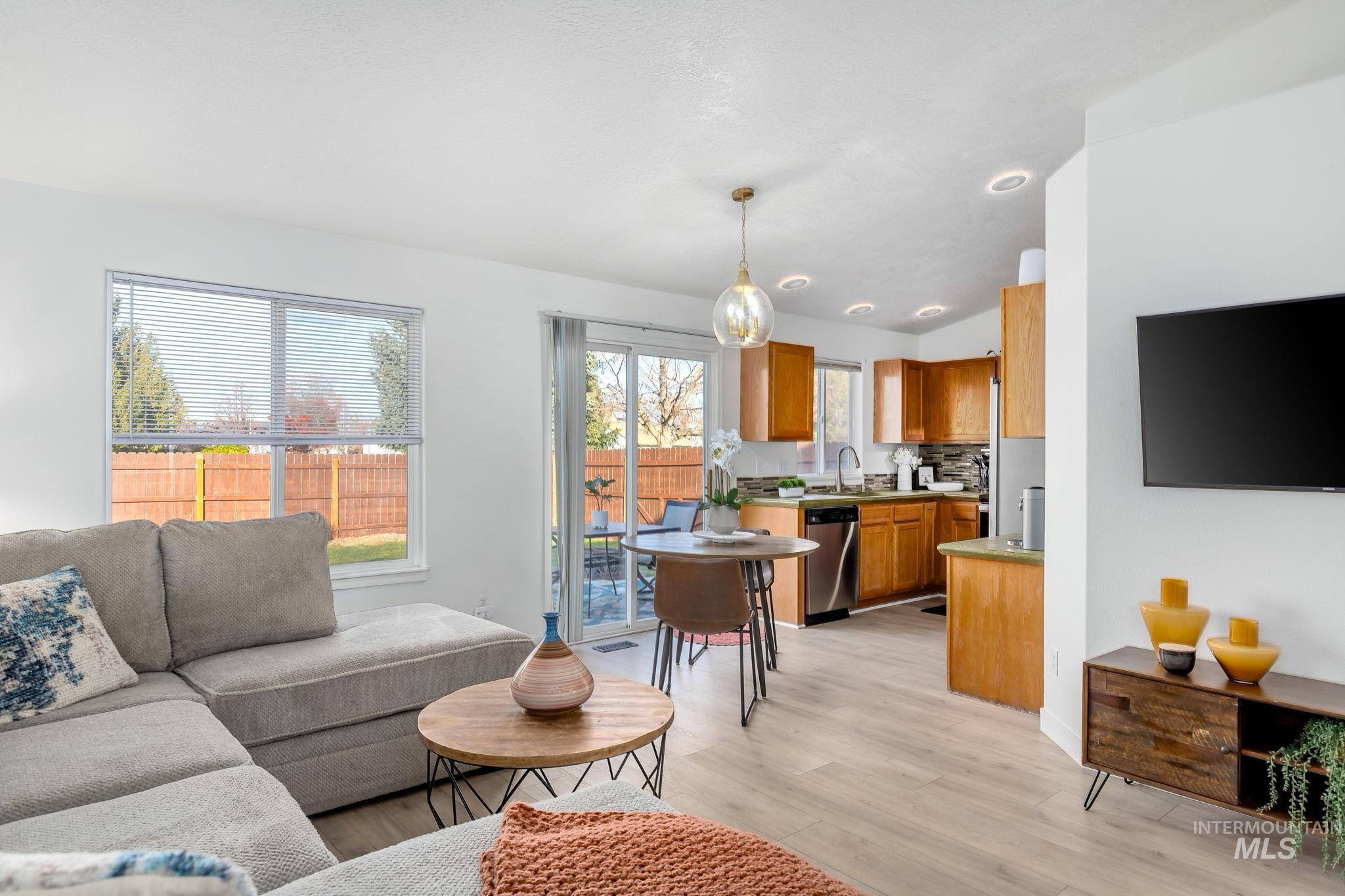 Living room with light wood-type flooring and lofted ceiling