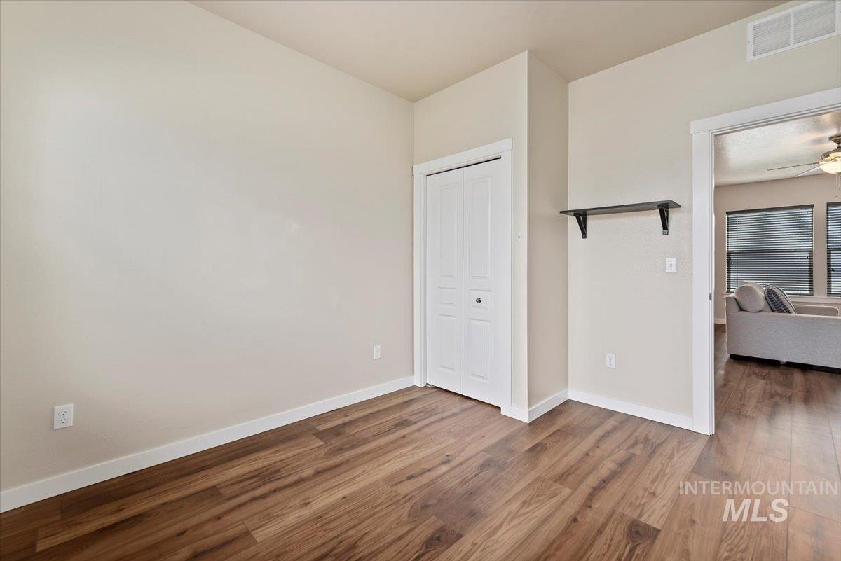 Unfurnished bedroom 1 with wood finished floors and a closet