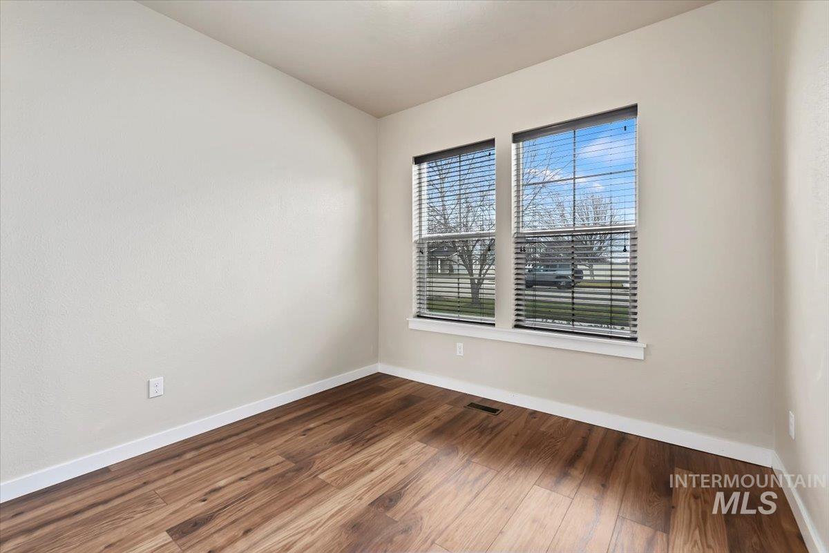 Bedroom 1 with dark wood-style flooring and baseboards