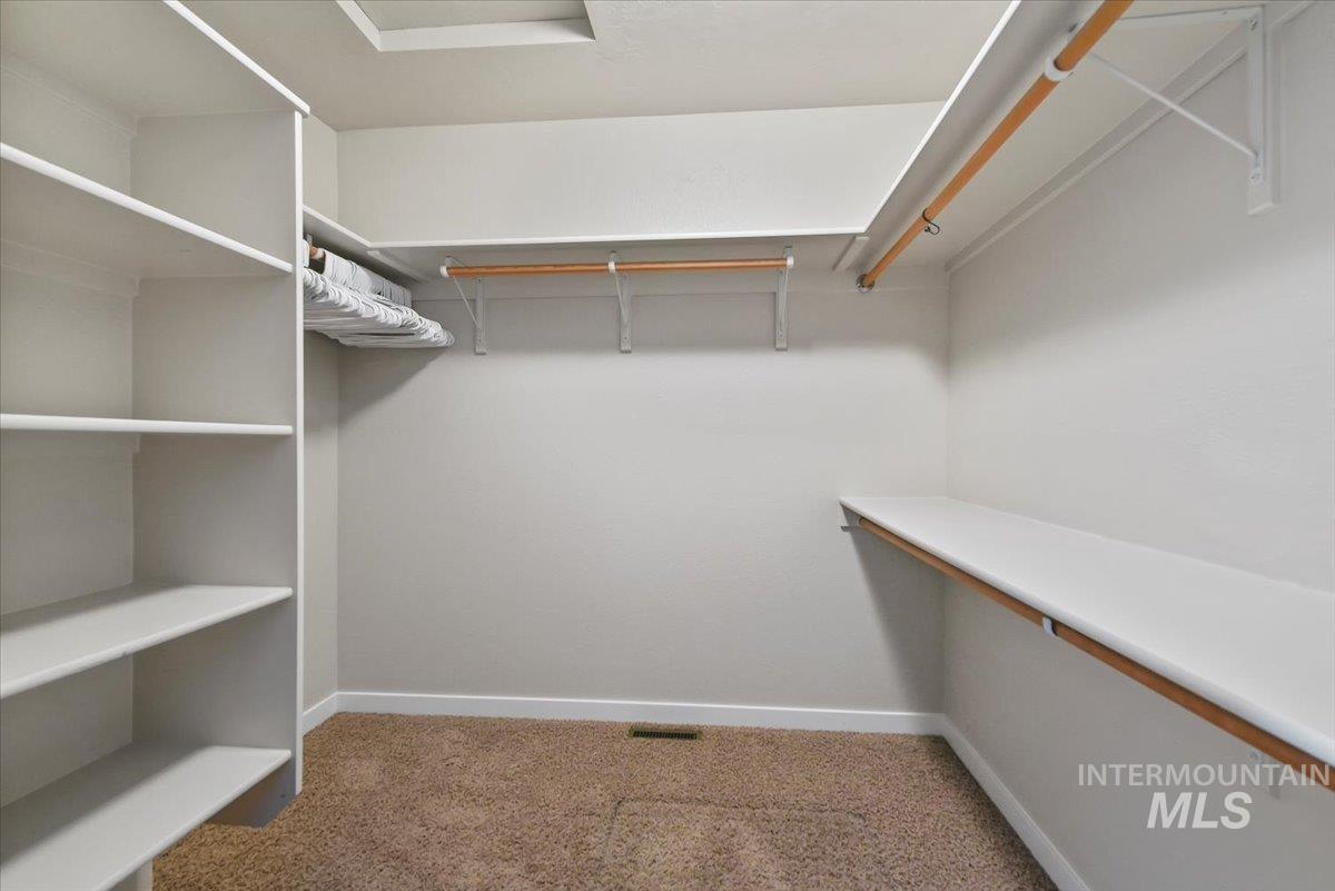 Spacious closet featuring light colored carpet