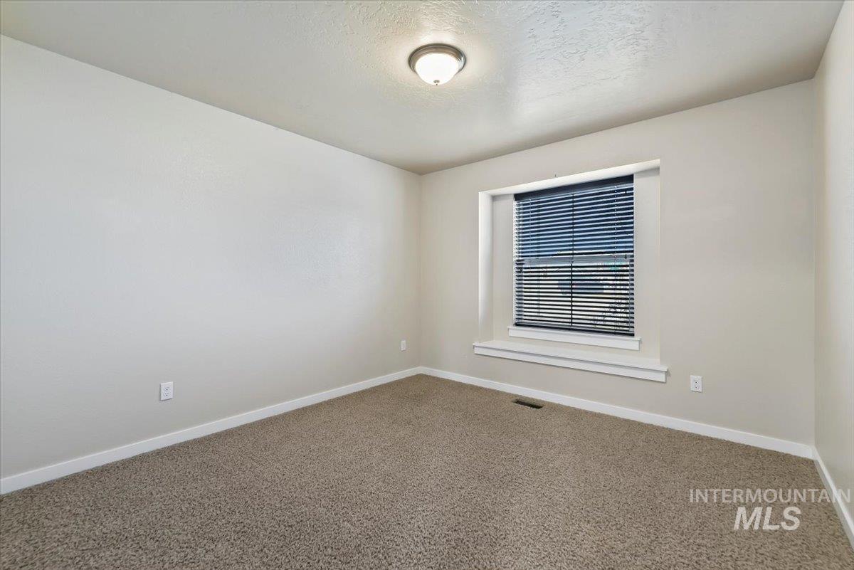 Carpeted bedroom 3 featuring baseboards and a textured ceiling