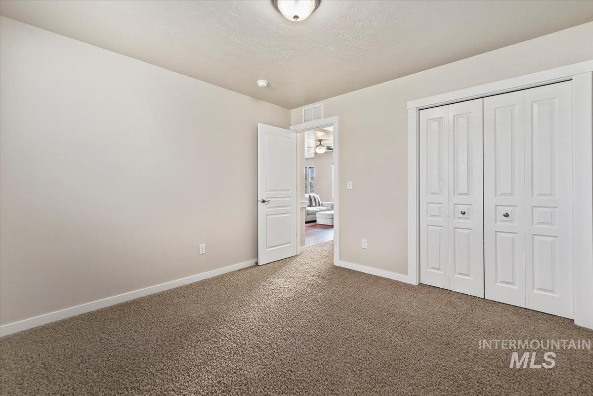 Unfurnished bedroom 3 featuring a closet, carpet, and a textured ceiling