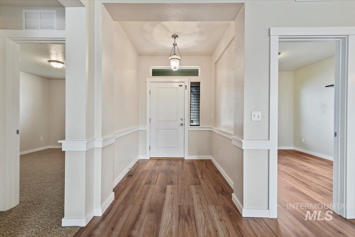 Entrance foyer with baseboards and dark wood-type flooring