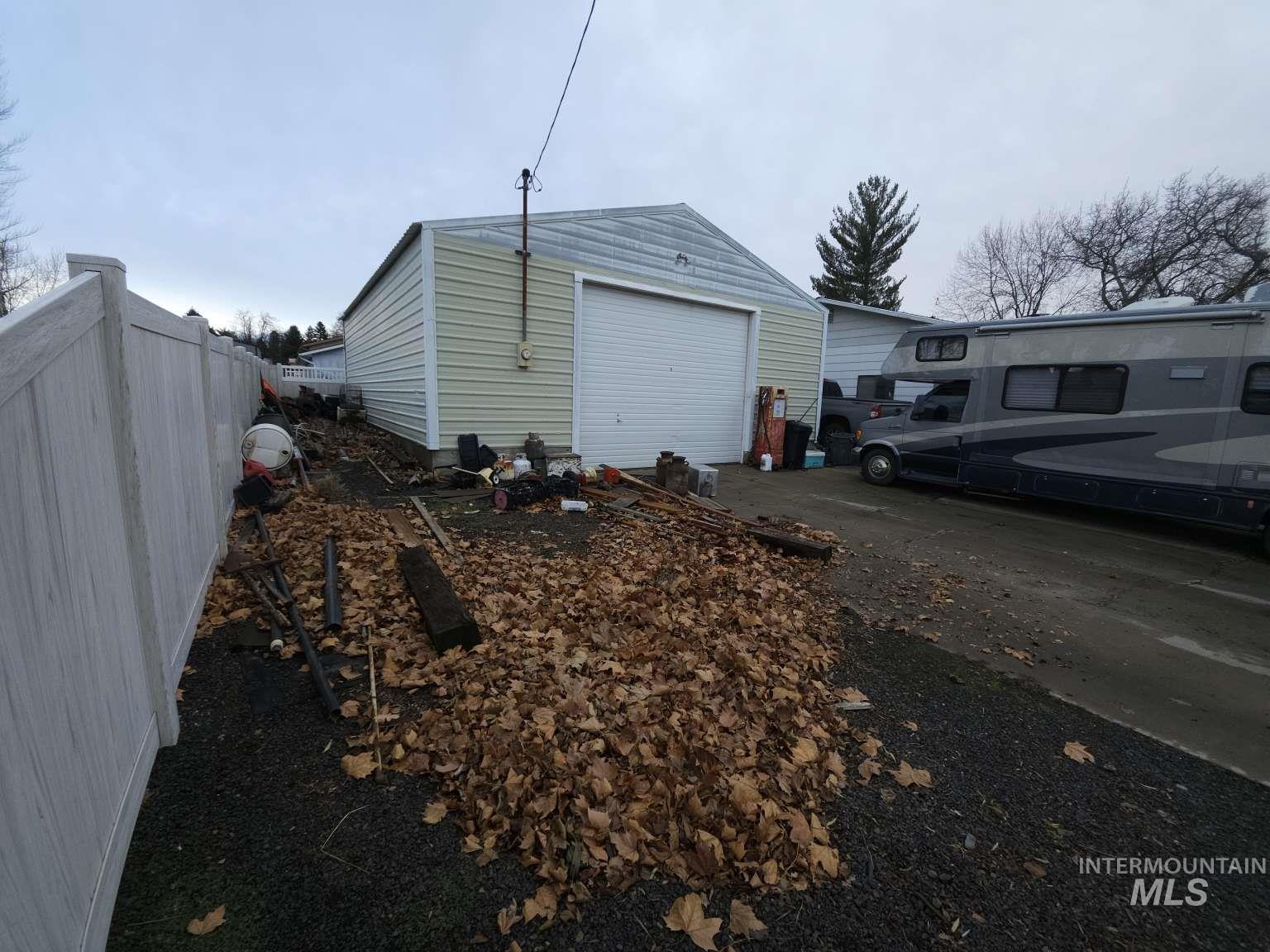 View of property exterior featuring an outdoor structure and driveway