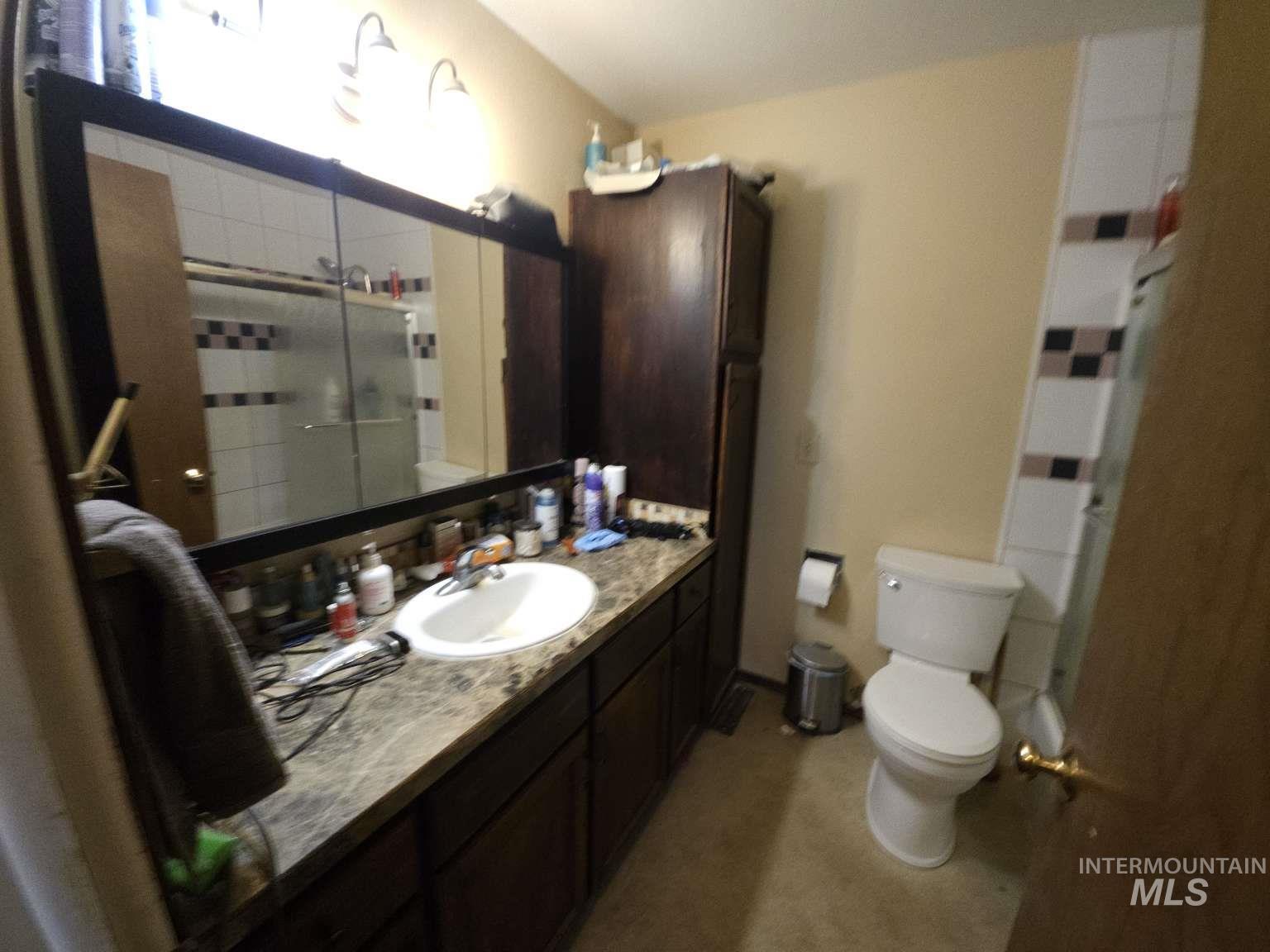 Full bath featuring tiled shower and vanity