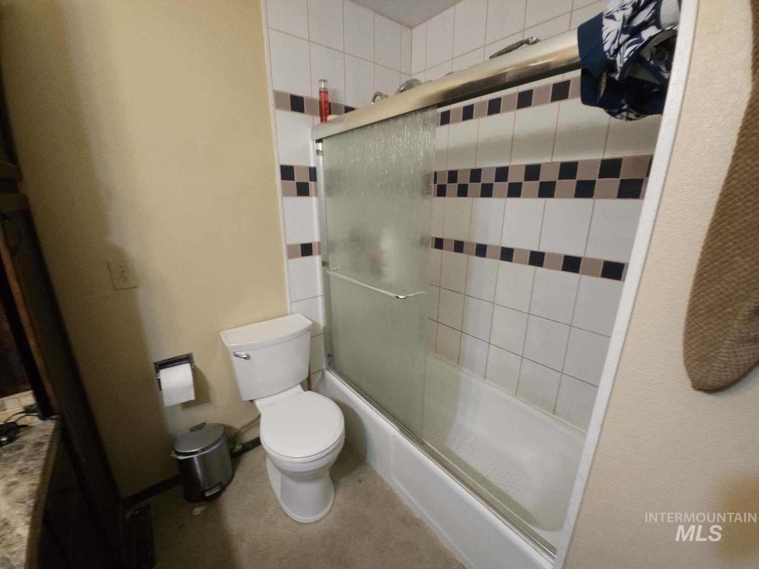 Full bathroom with enclosed tub / shower combo and vanity