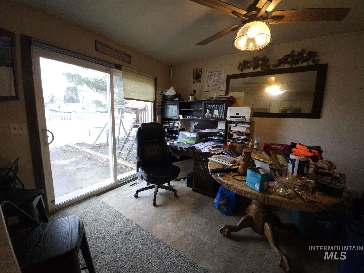 Home office featuring ceiling fan and light flooring