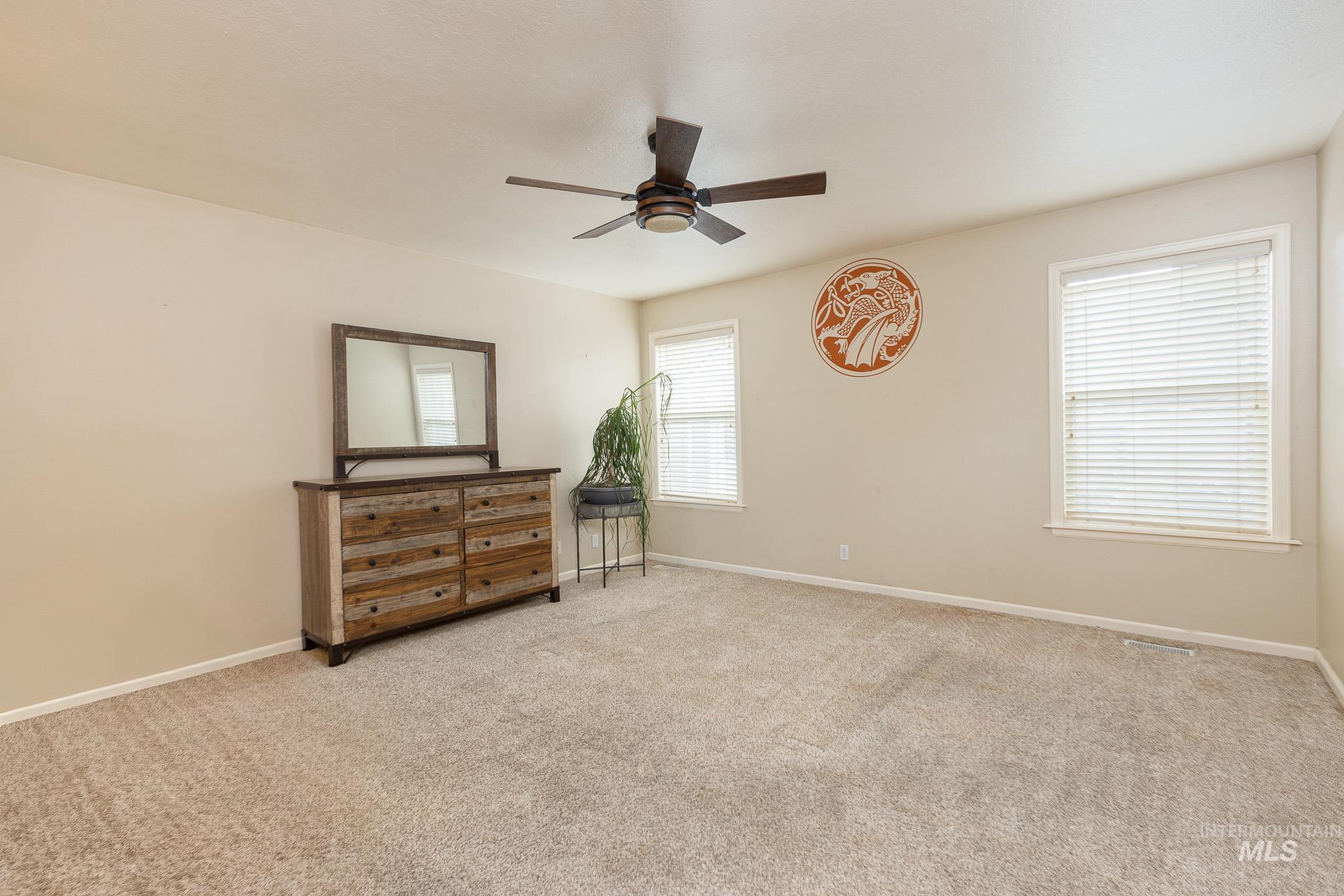 Bedroom with light colored carpet and ceiling fan