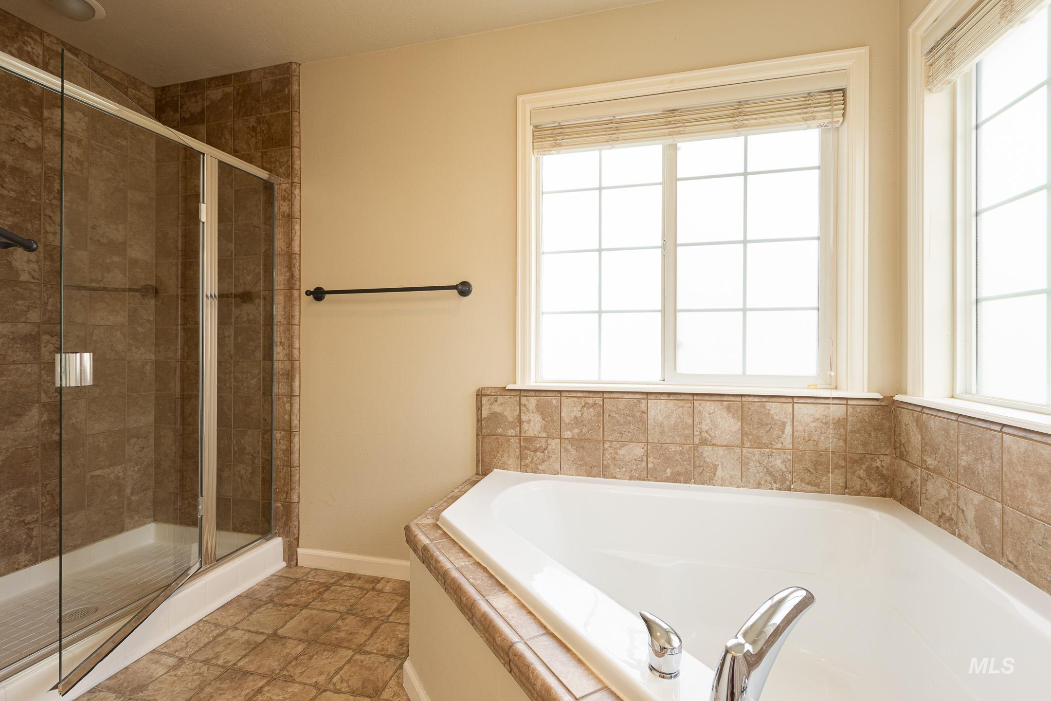 Bathroom featuring a stall shower and a garden tub
