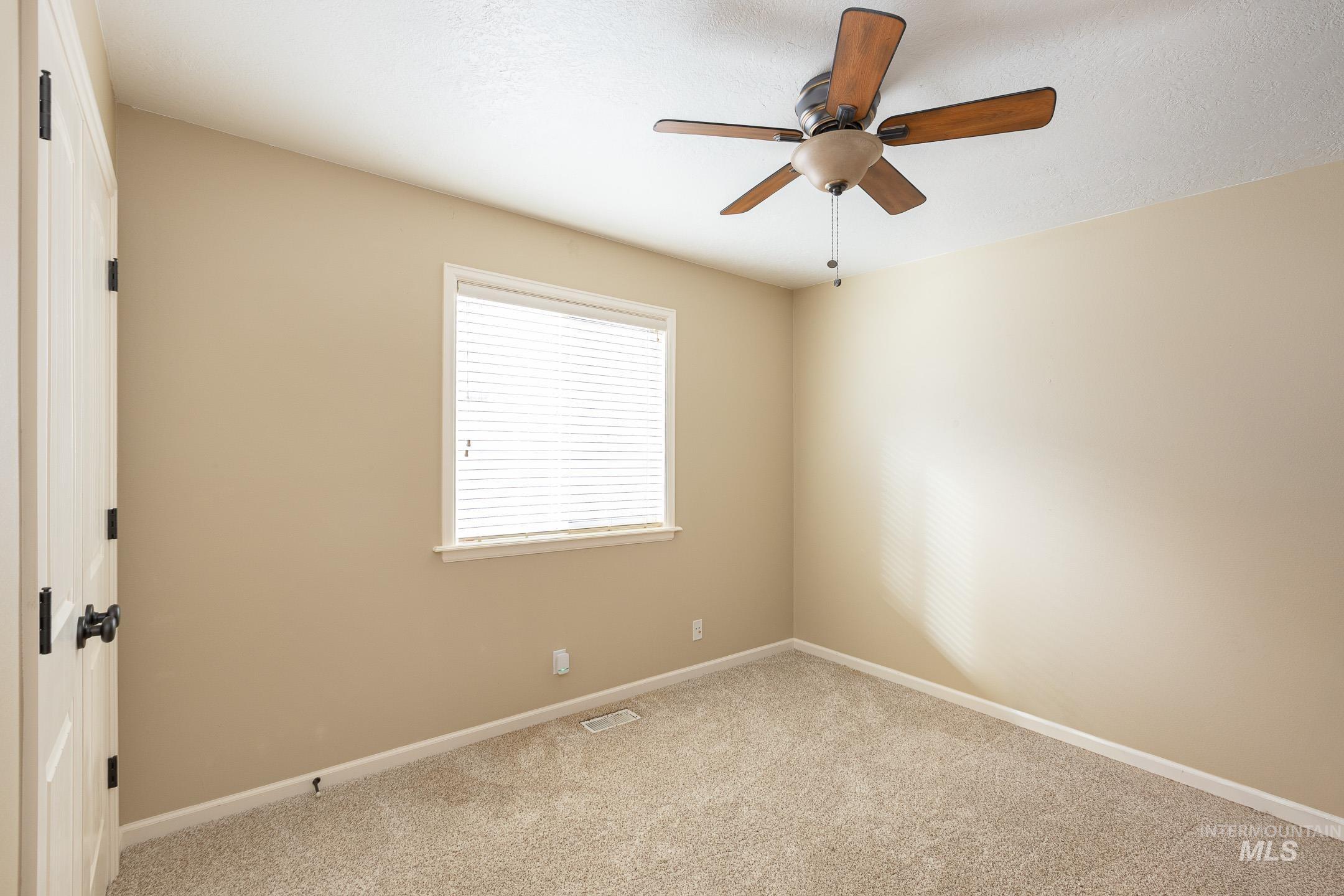 Spare room with carpet flooring and a ceiling fan