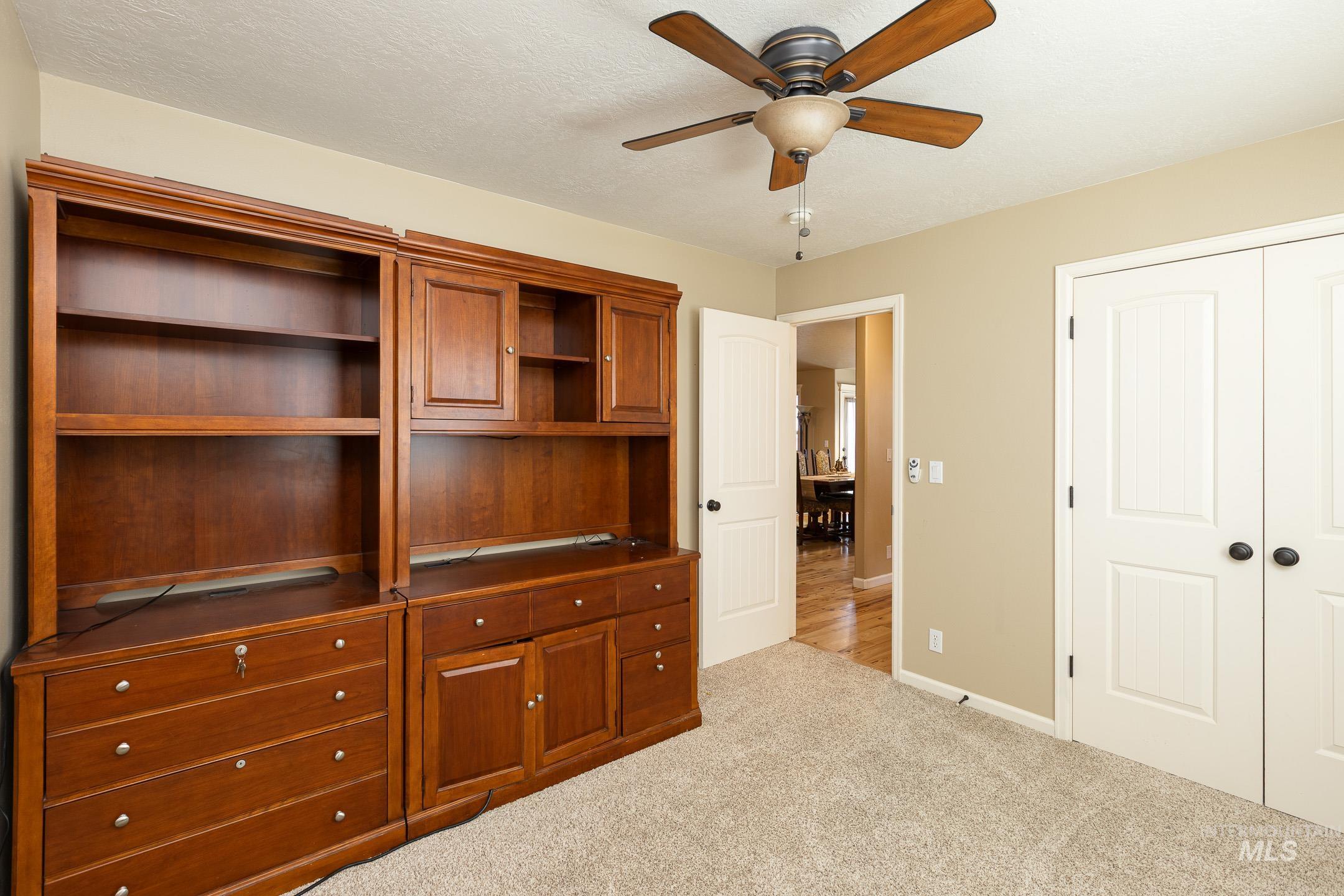 Unfurnished bedroom featuring carpet floors, a ceiling fan, a closet, and a textured ceiling
