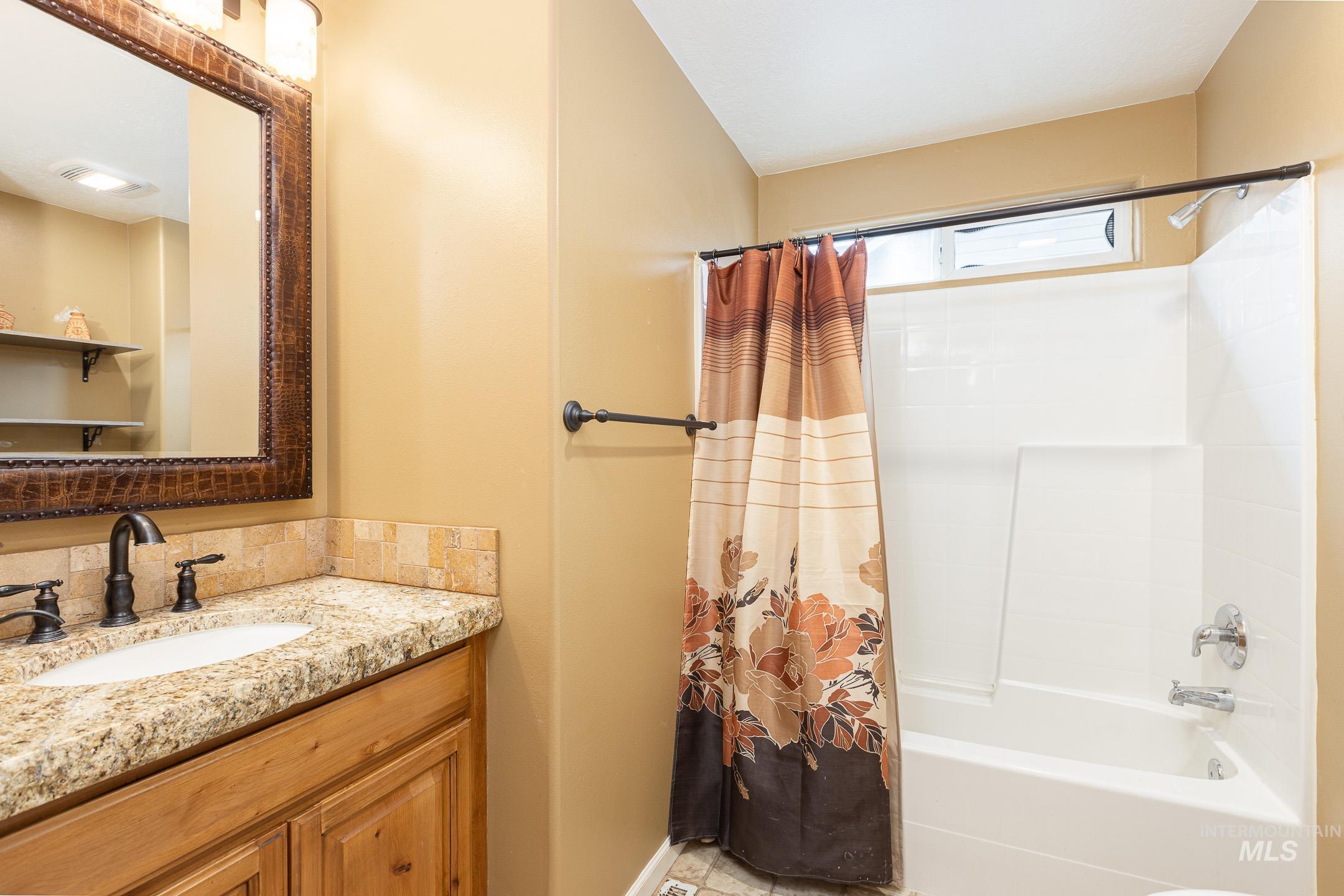 Bathroom with vanity and shower / bath combo with shower curtain