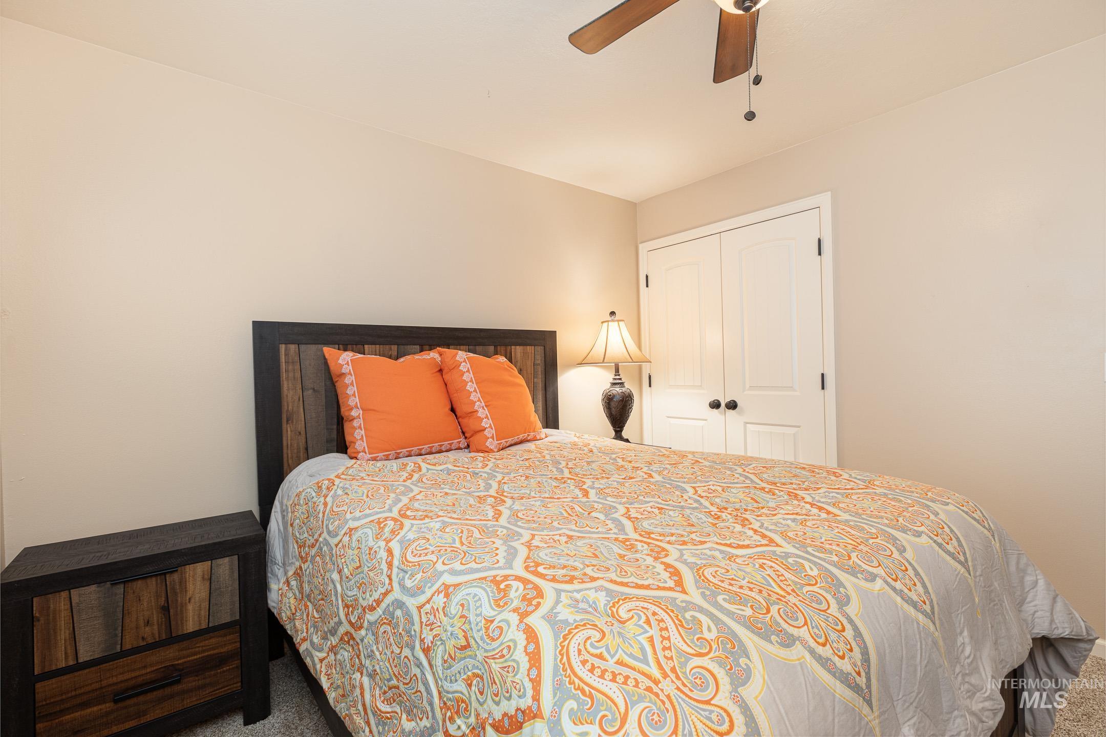 Bedroom with carpet, a ceiling fan, and a closet