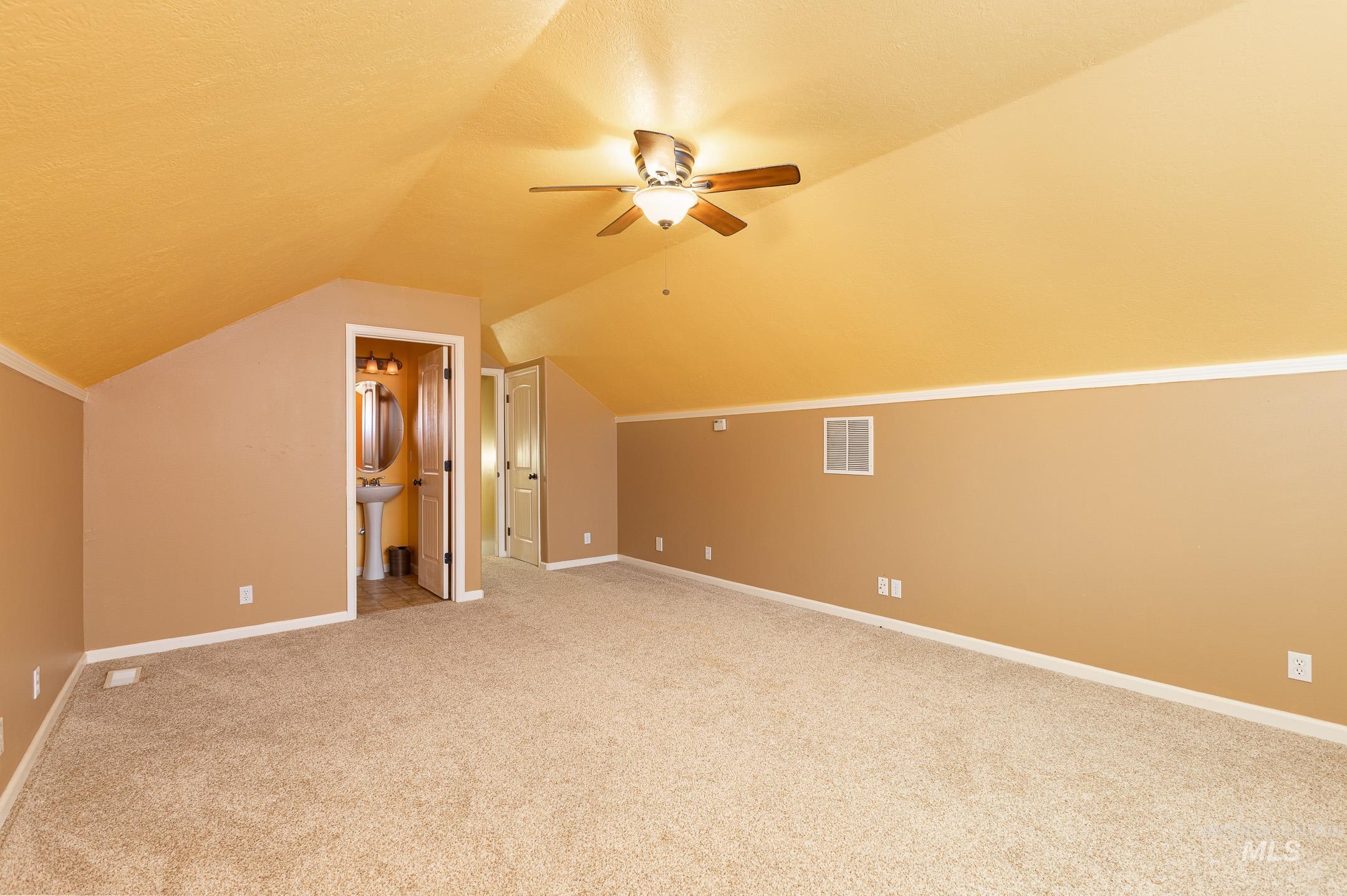 Additional living space with light carpet, lofted ceiling, a textured ceiling, and ceiling fan