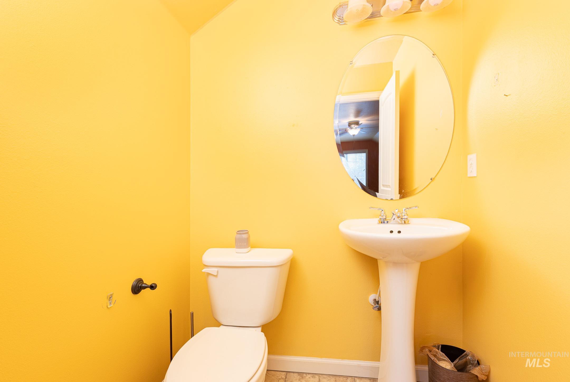 Half bathroom featuring toilet and baseboards