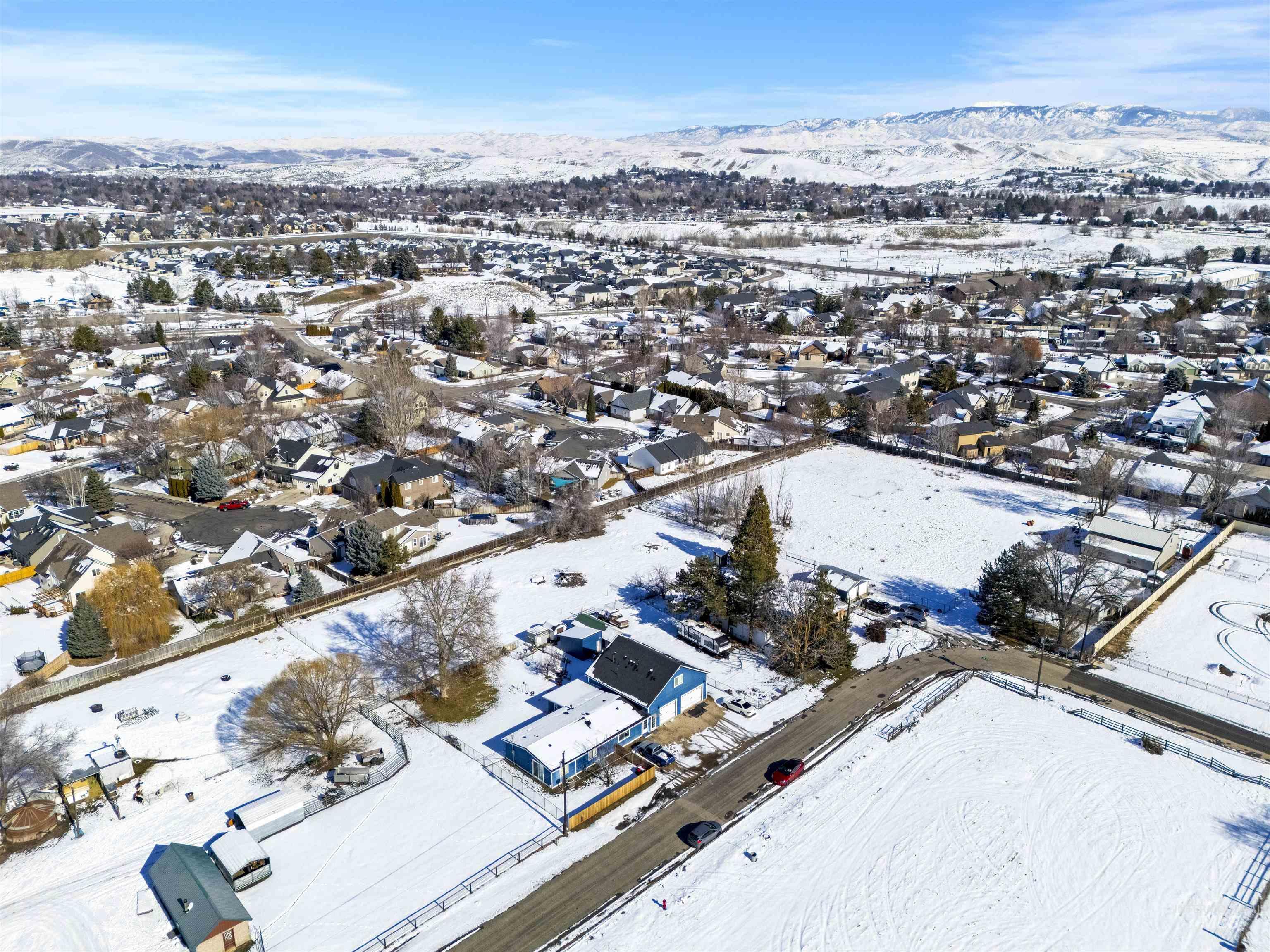 Snowy aerial view featuring a residential view and a mountain view