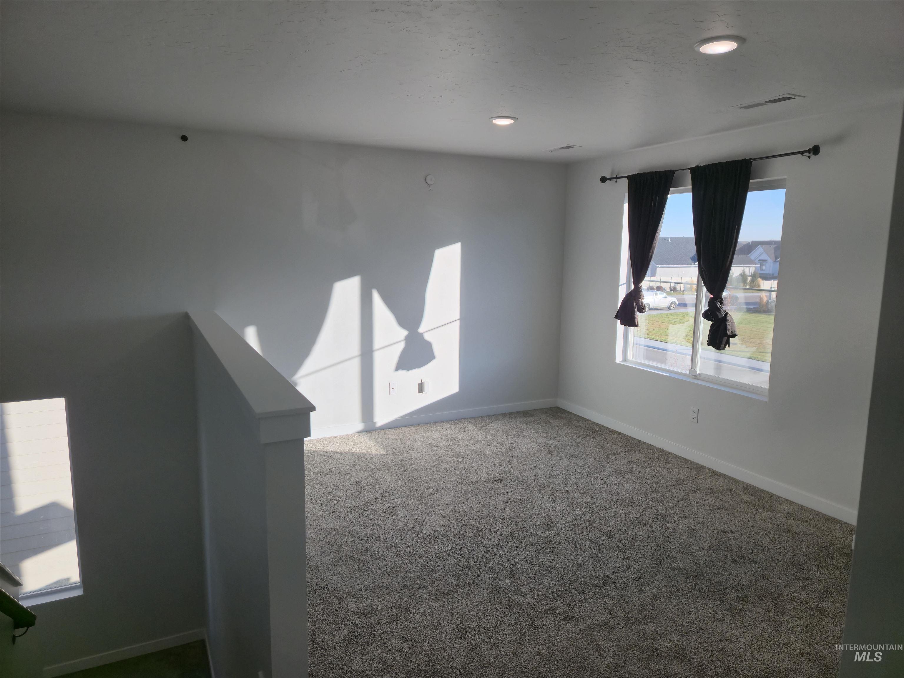 Carpeted empty room with baseboards and recessed lighting