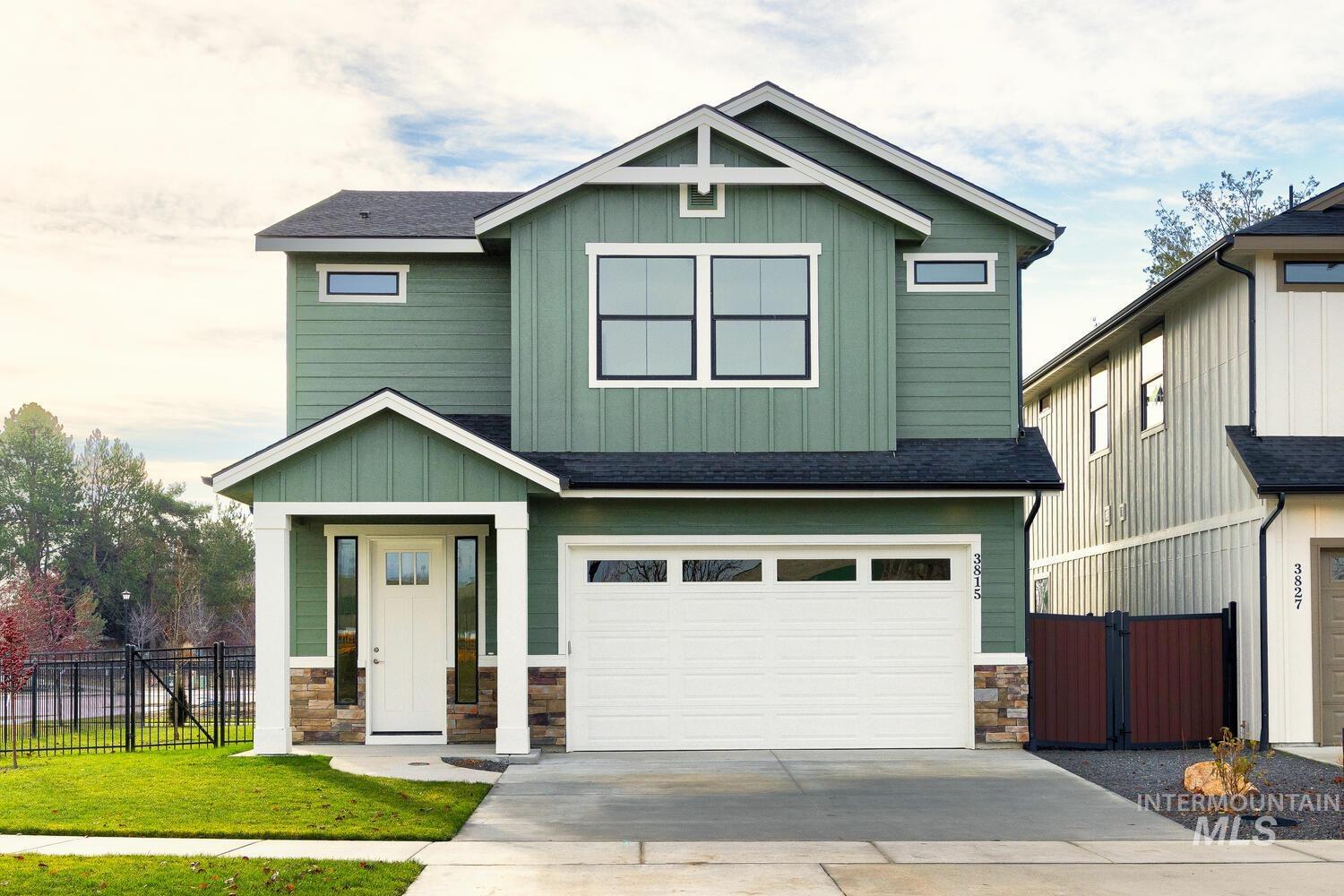Craftsman house featuring board and batten siding, a shingled roof, stone siding, an attached garage, and driveway