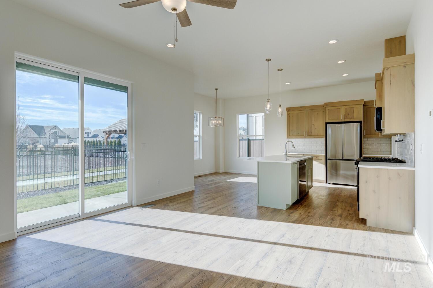 Kitchen featuring pendant lighting, a kitchen island with sink, appliances with stainless steel finishes, light wood finished floors, and recessed lighting