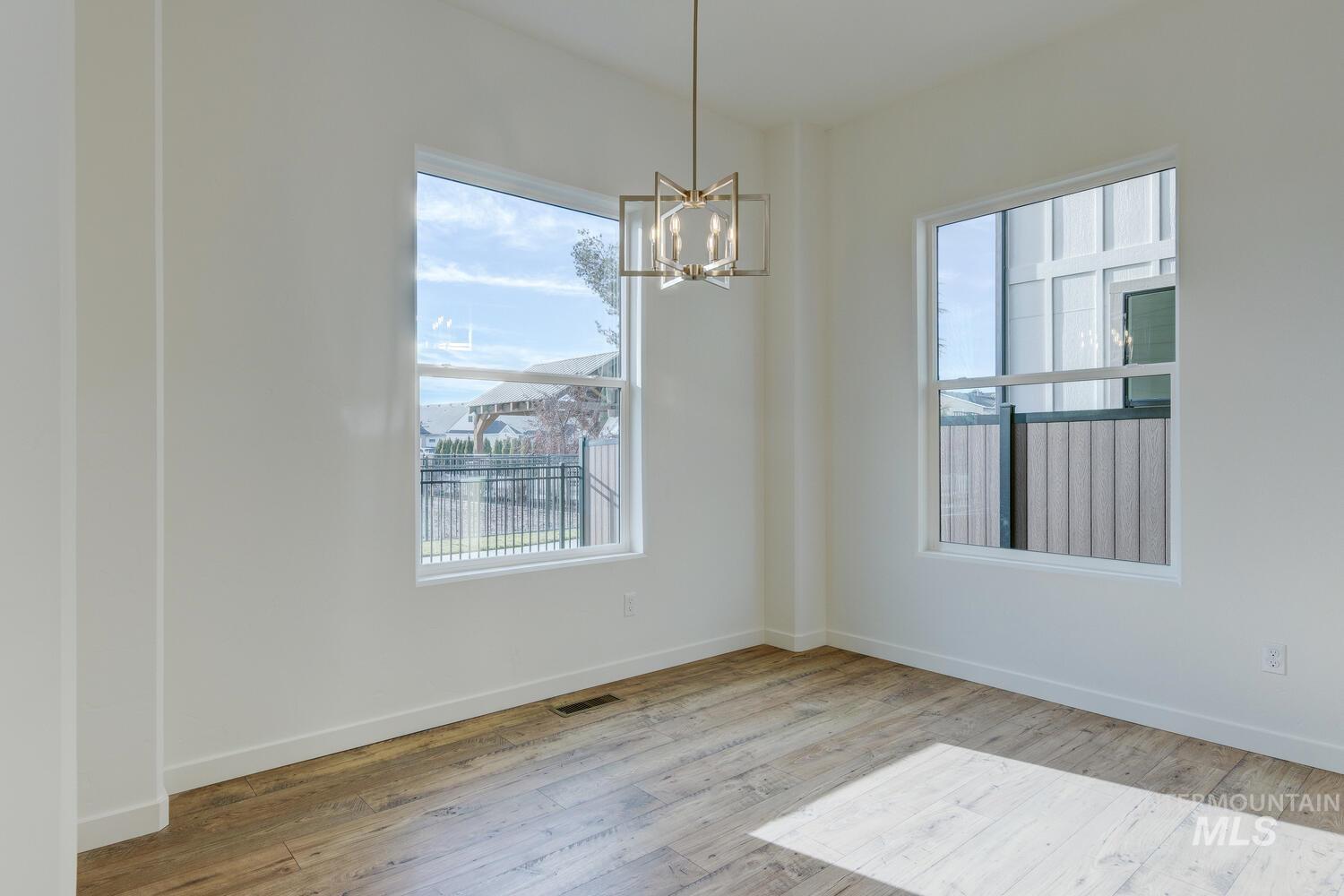Unfurnished dining area with a chandelier, plenty of natural light, and light wood-style flooring