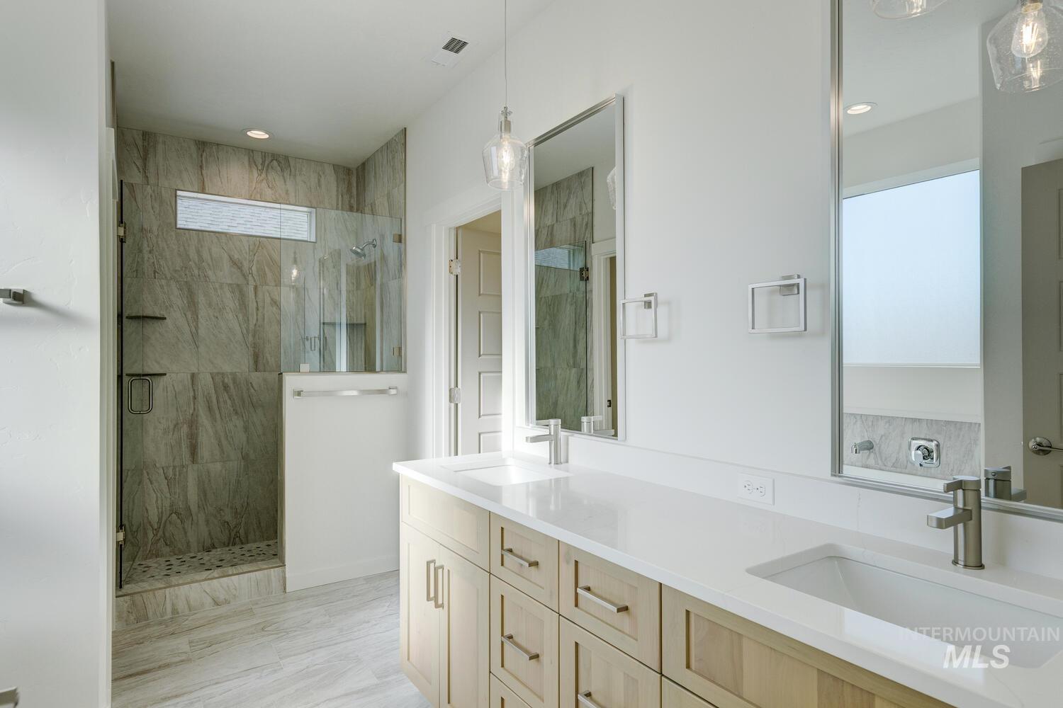 Bathroom with double vanity and a stall shower