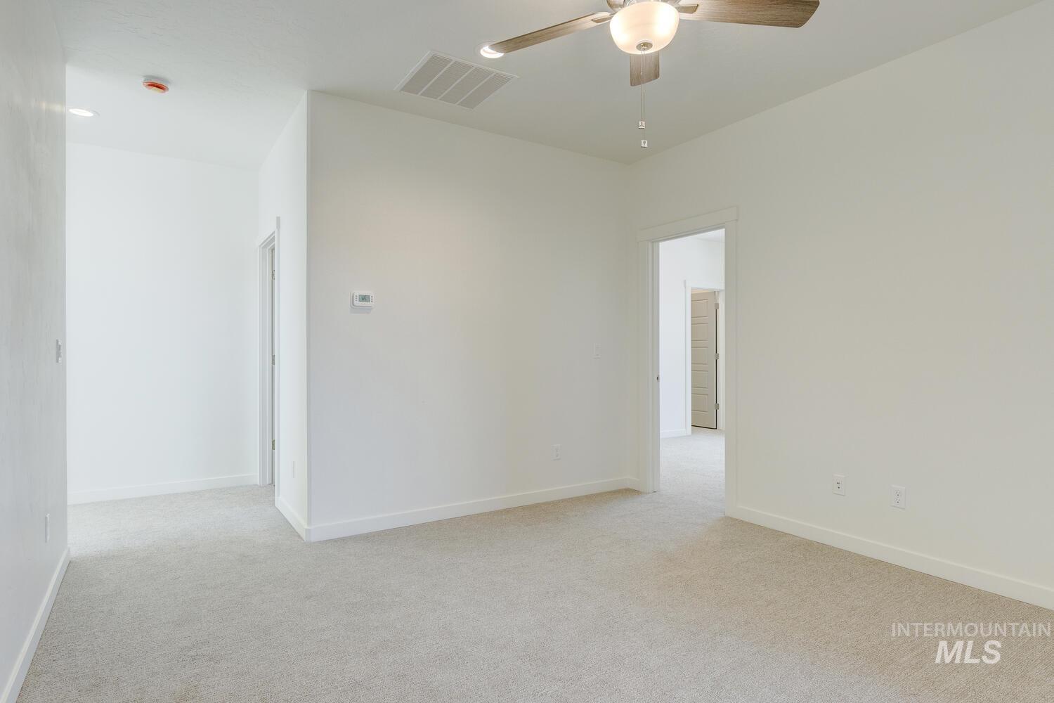 Unfurnished room with light carpet and a ceiling fan