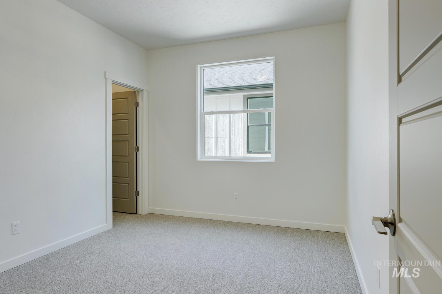 Empty room featuring light carpet and baseboards