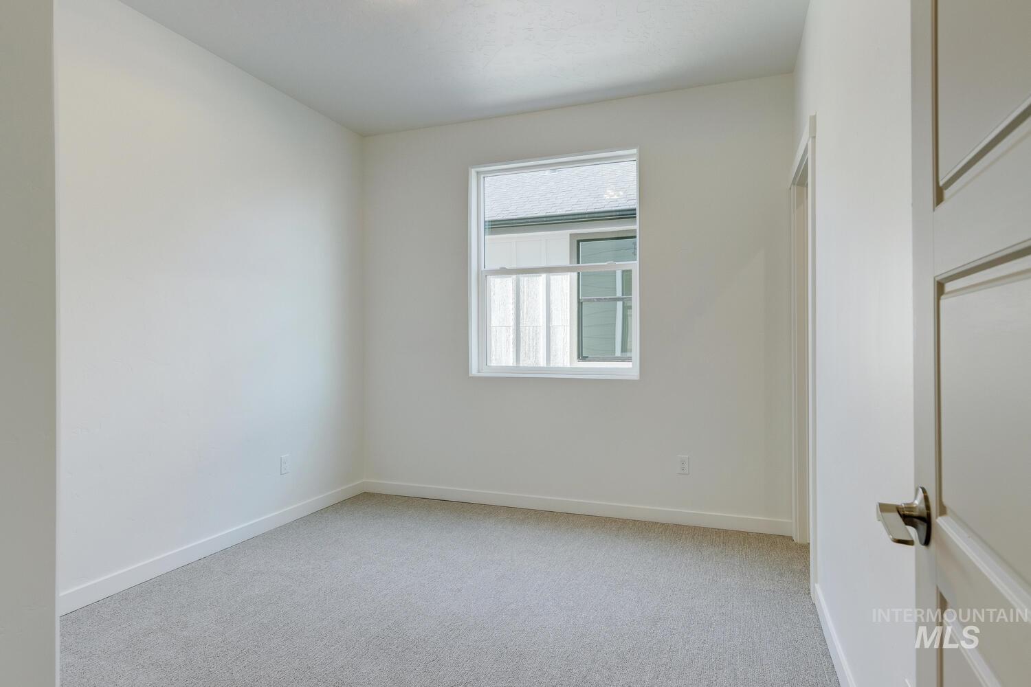 Unfurnished room with light colored carpet and baseboards