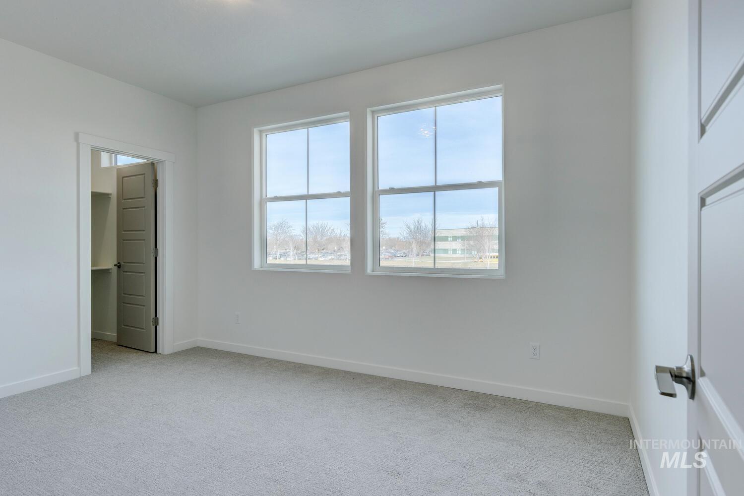 Unfurnished bedroom with light carpet and a spacious closet