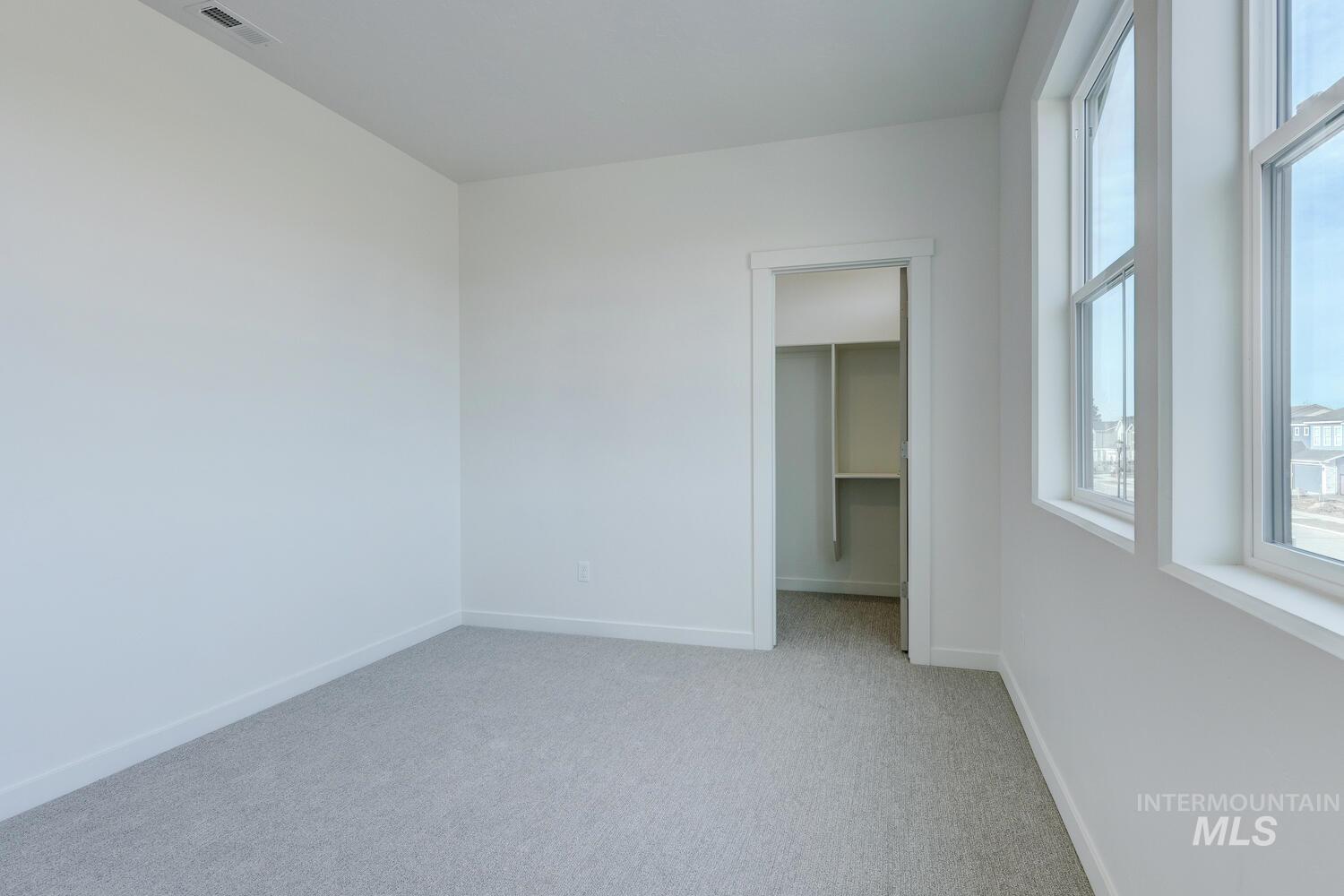 Empty room with light carpet and baseboards