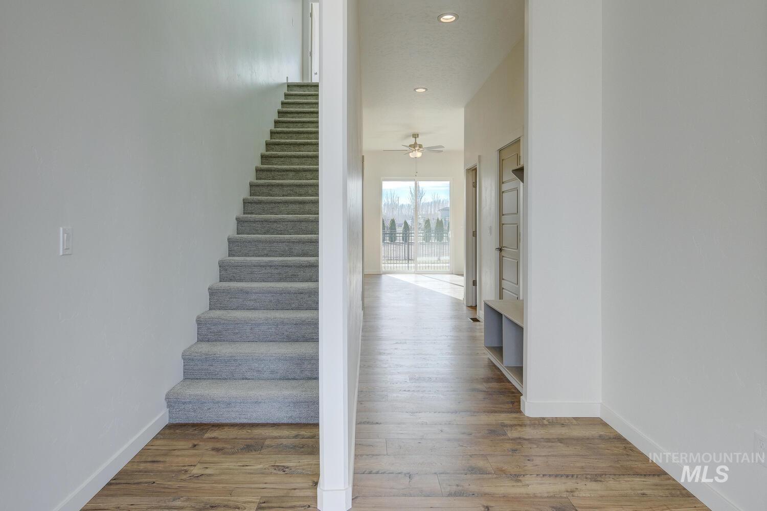 Stairway with wood finished floors and recessed lighting